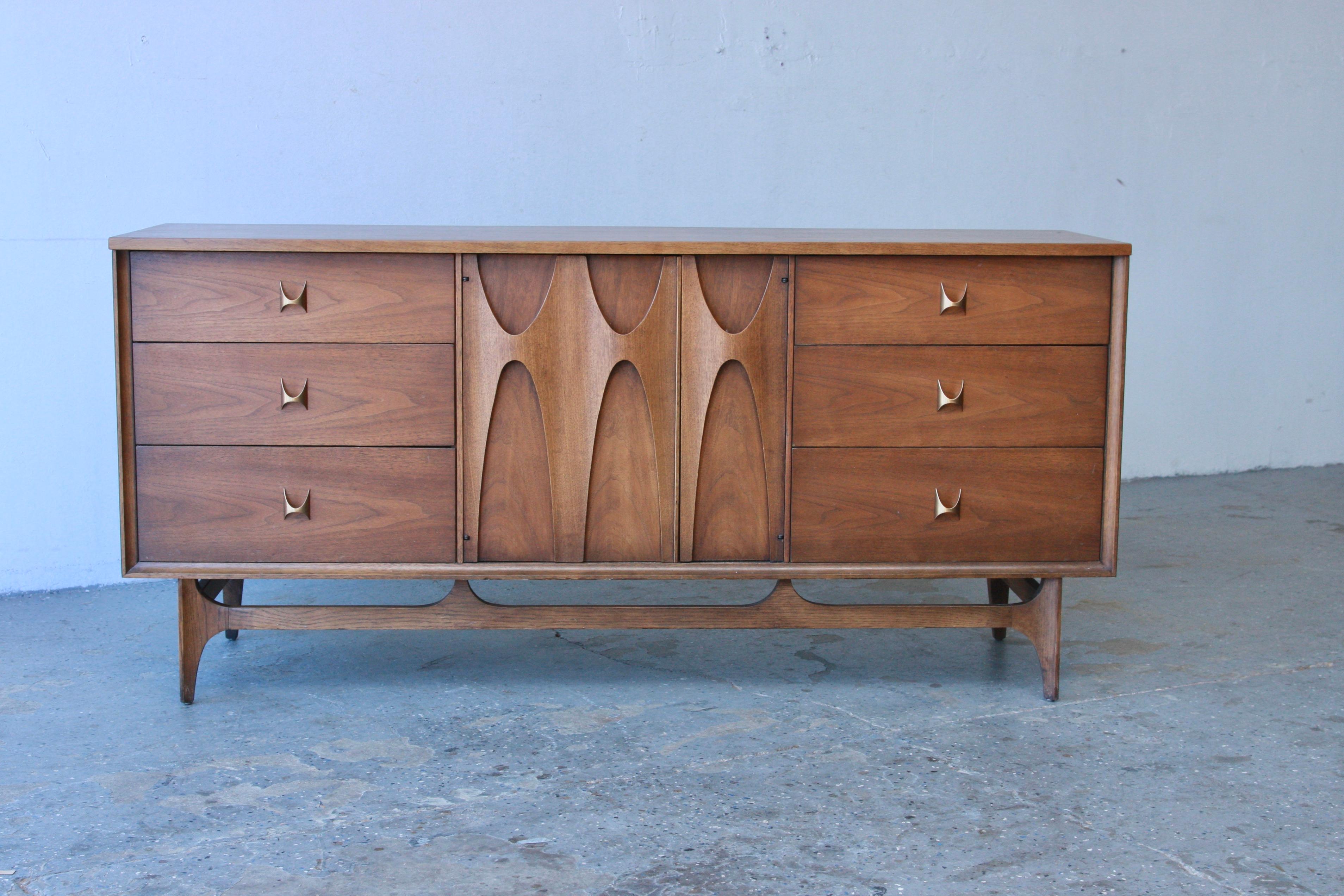 Mid-Century Modern Broyhill Brasilia Dresser. This exceptional piece is highly coveted by collectors of Brasilia and Mid-Century Modern furniture. Showcasing the iconic elongated, inverted sculpted arches and brass hand pulls, it boasts exquisite