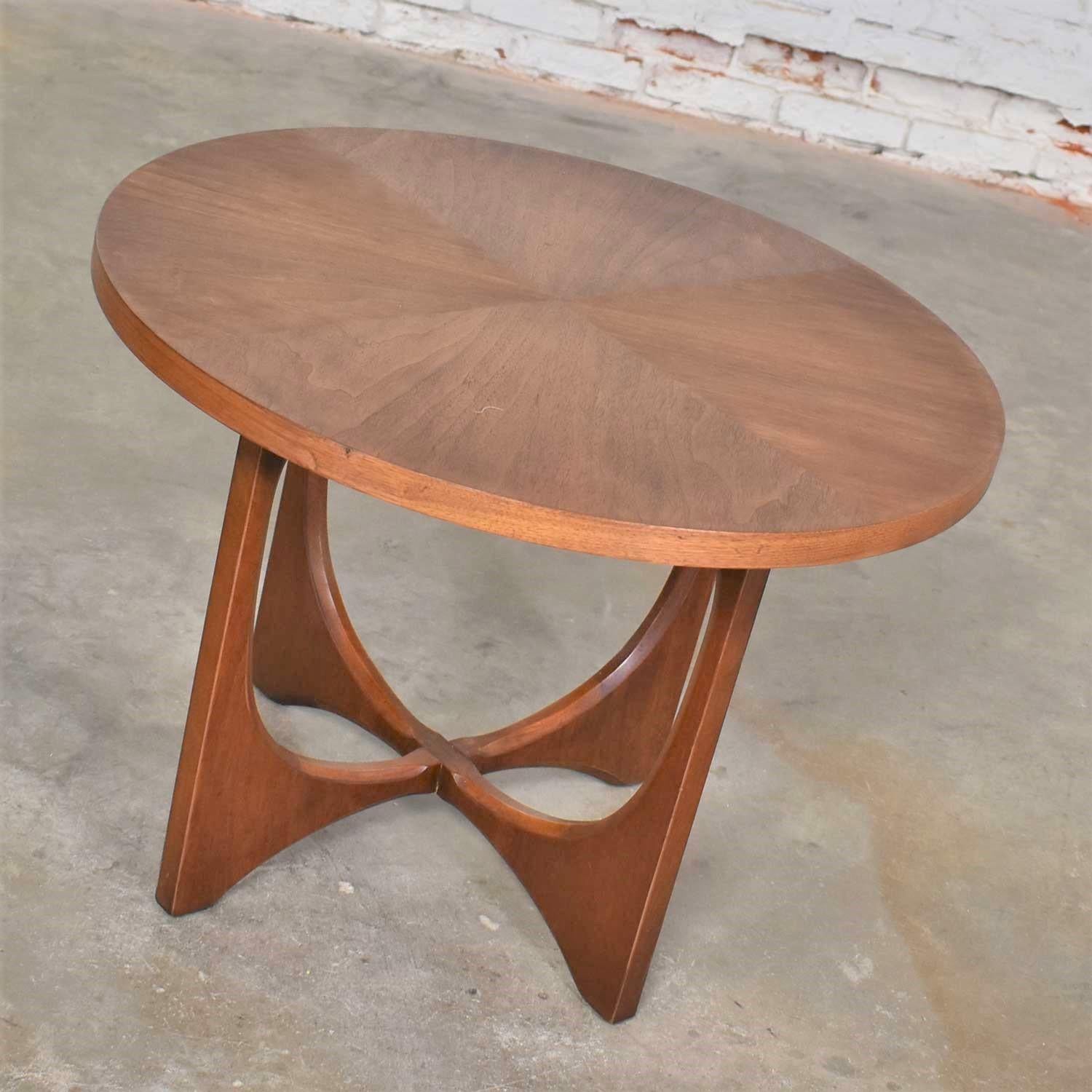 Handsome mid-century modern round lamp table, end table, or side table by Broyhill for their Brasilia collection. It is in fabulous vintage condition. The top has been refinished and restored and the base restored. They still retain a warm vintage