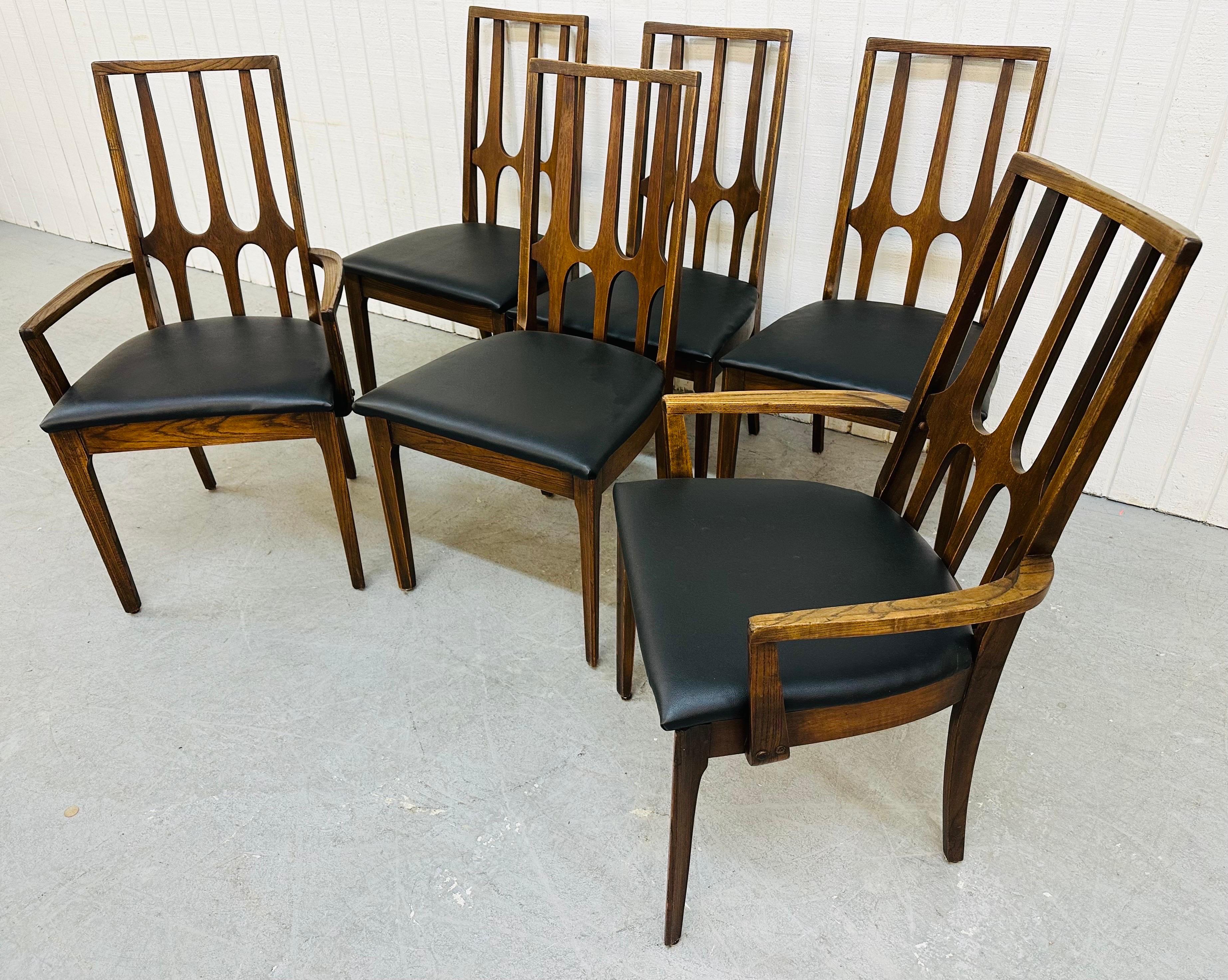 This listing is for a set of six Mid-Century Modern Broyhill Brasilia Walnut Dining Chairs. Featuring two arm chairs, four straight chairs, newly upholstered black vinyl seats, and sculpted high back rests. This is an exceptional combination of