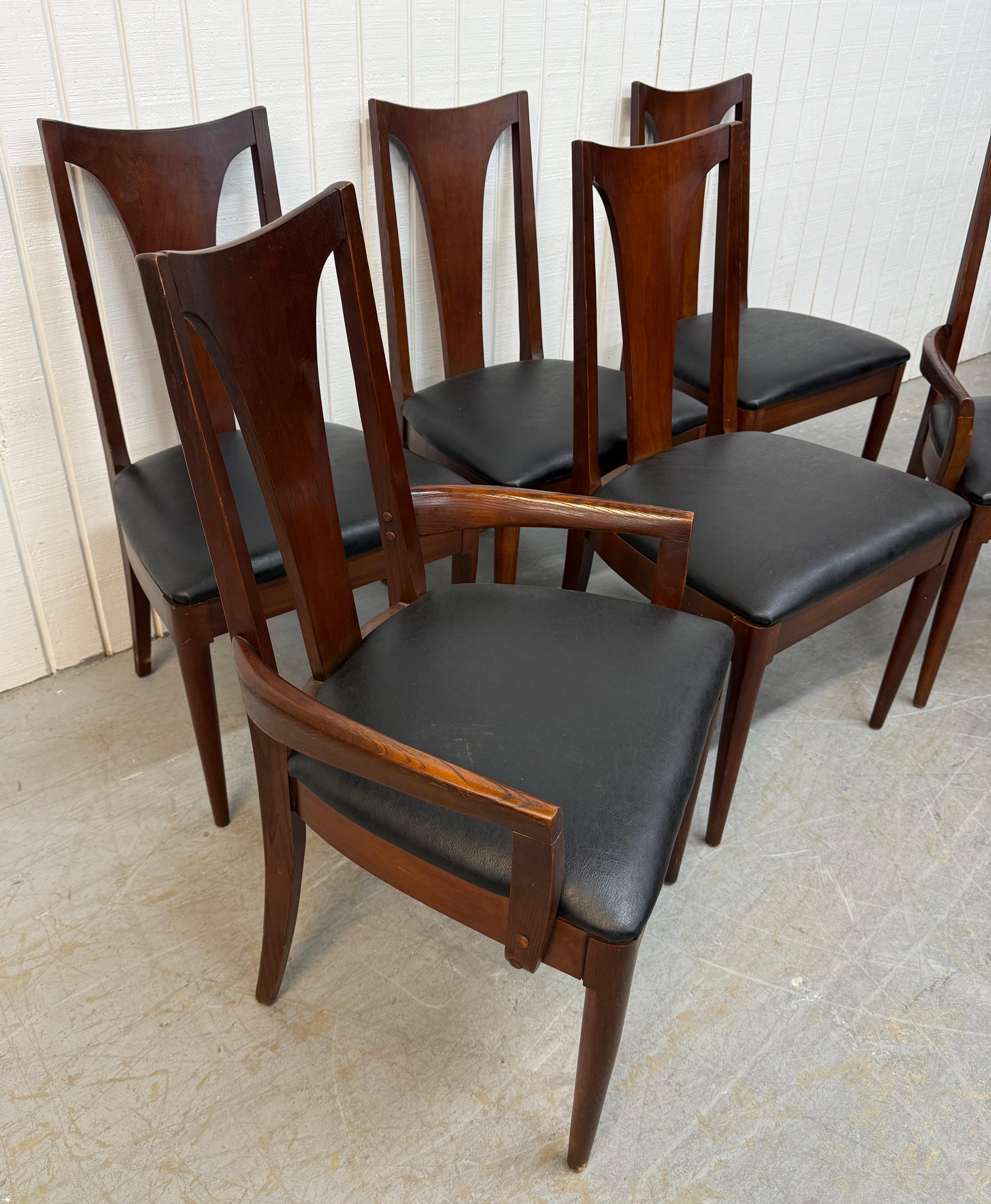 This listing is for a set of six Mid-Century Modern Broyhill Brasilia Walnut Dining Chairs. Featuring a curved back design, two arm chairs, four side chairs, modern legs, and new black vinyl upholstery. This is an exceptional combination of quality