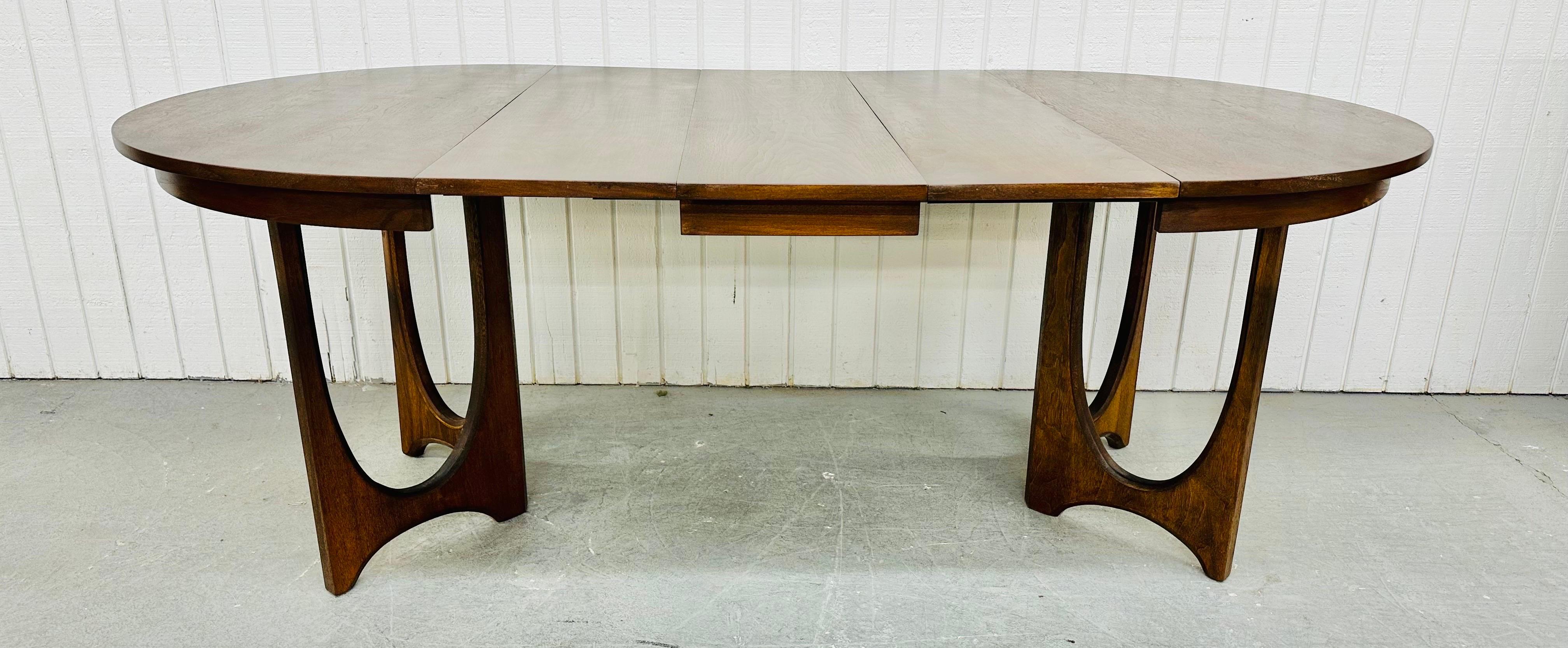 This listing is for a Mid-Century Modern Broyhill Brasilia Walnut Dining Table. Featuring a round 44” top that expands up to 80” L with three leaves, sculpted Brasilia pedestal legs, and a beautiful walnut finish. This is an exceptional combination