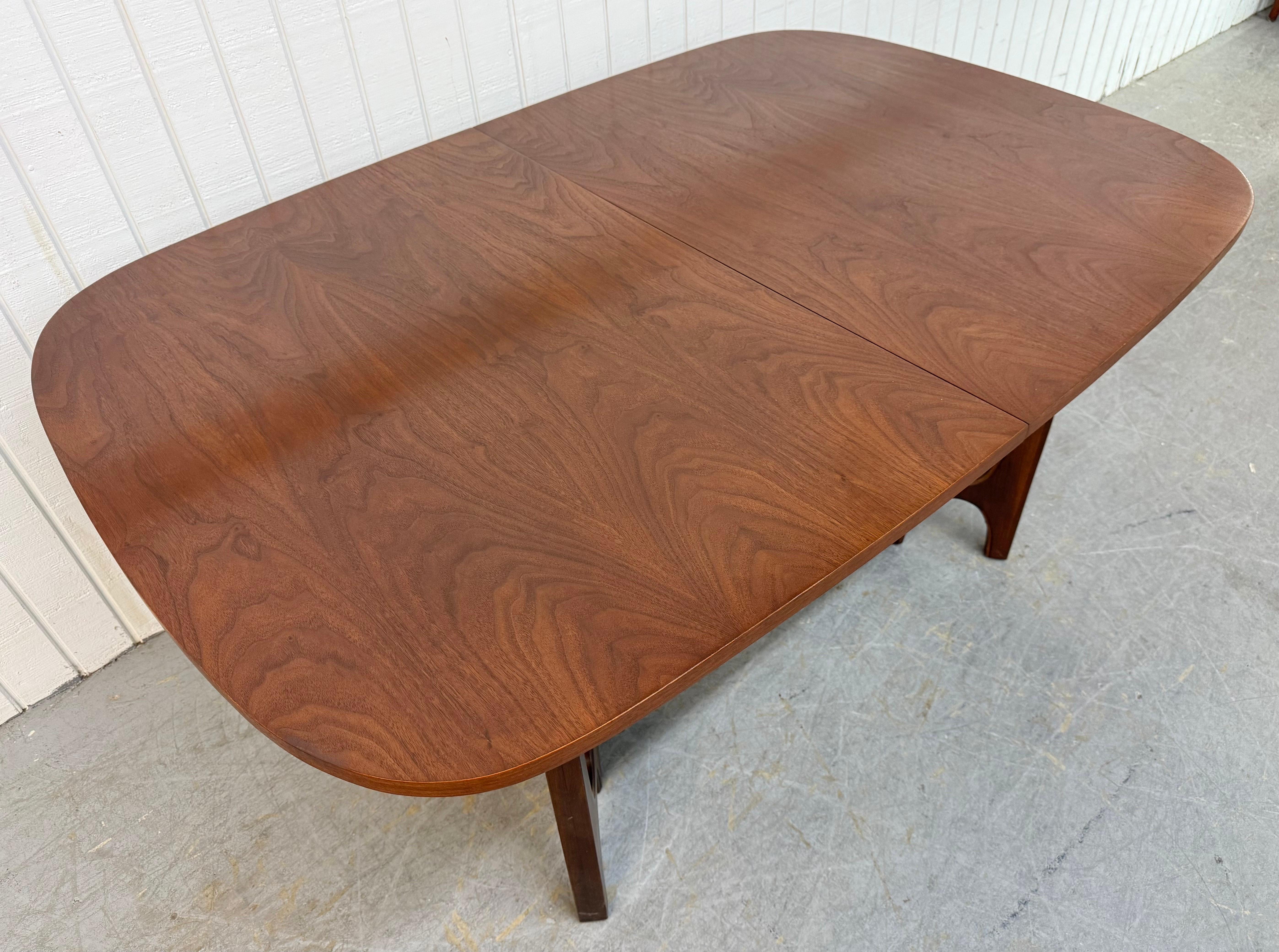 Este anuncio es para una mesa de comedor Broyhill Brasilia de nogal, moderna de mediados de siglo. Con un tablero de diseño ovalado, patas esculpidas de diseño arqueado Brasilia, dos hojas que amplían la mesa hasta 98,25