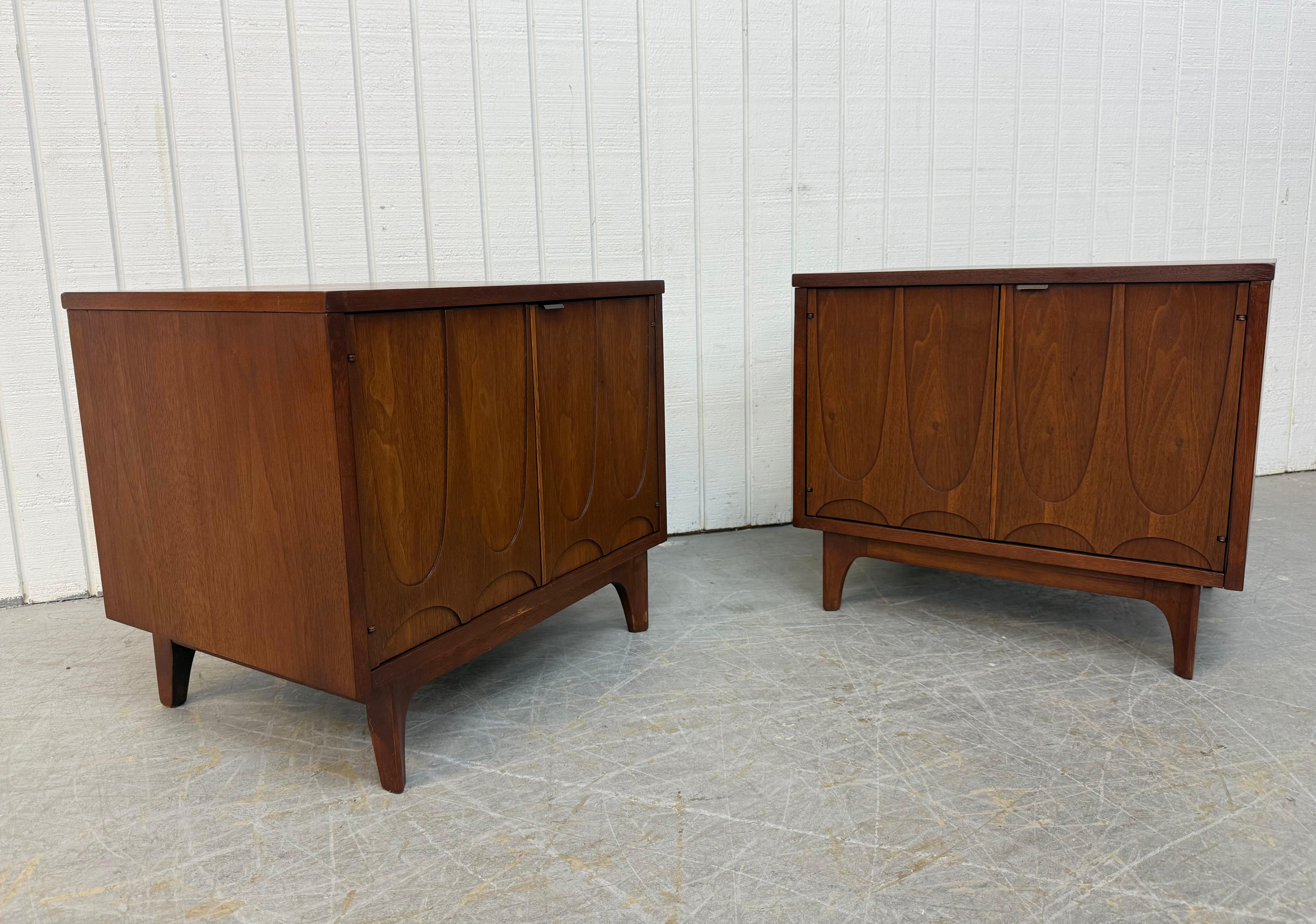 Diese Auflistung ist für ein Paar von Mid-Century Modern Broyhill Brasilia Walnuss Nachttische. Mit geradlinigem Design, zweitüriger Kommode, skulpturalen Türen, die sich zum Stauraum öffnen lassen, modernen Beinen und einem Finish in Walnuss. Dies