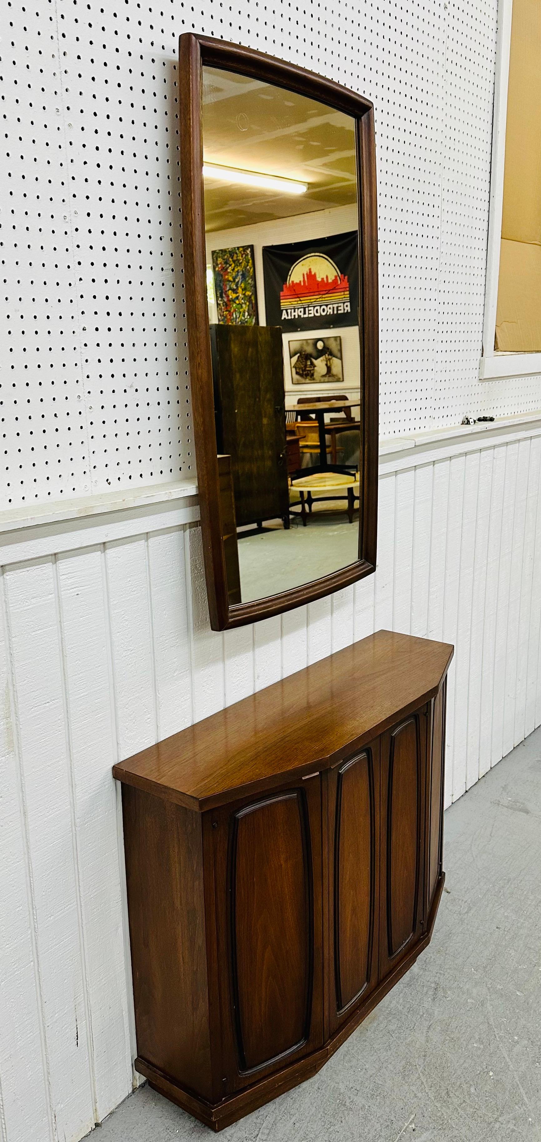 This listing is for a Mid-Century Modern Broyhill Emphasis Console & Mirror. Featuring a console table with two doors that open up to storage space, center door that opens up to a hidden drawer, matching rectangular mirror, and a beautiful walnut
