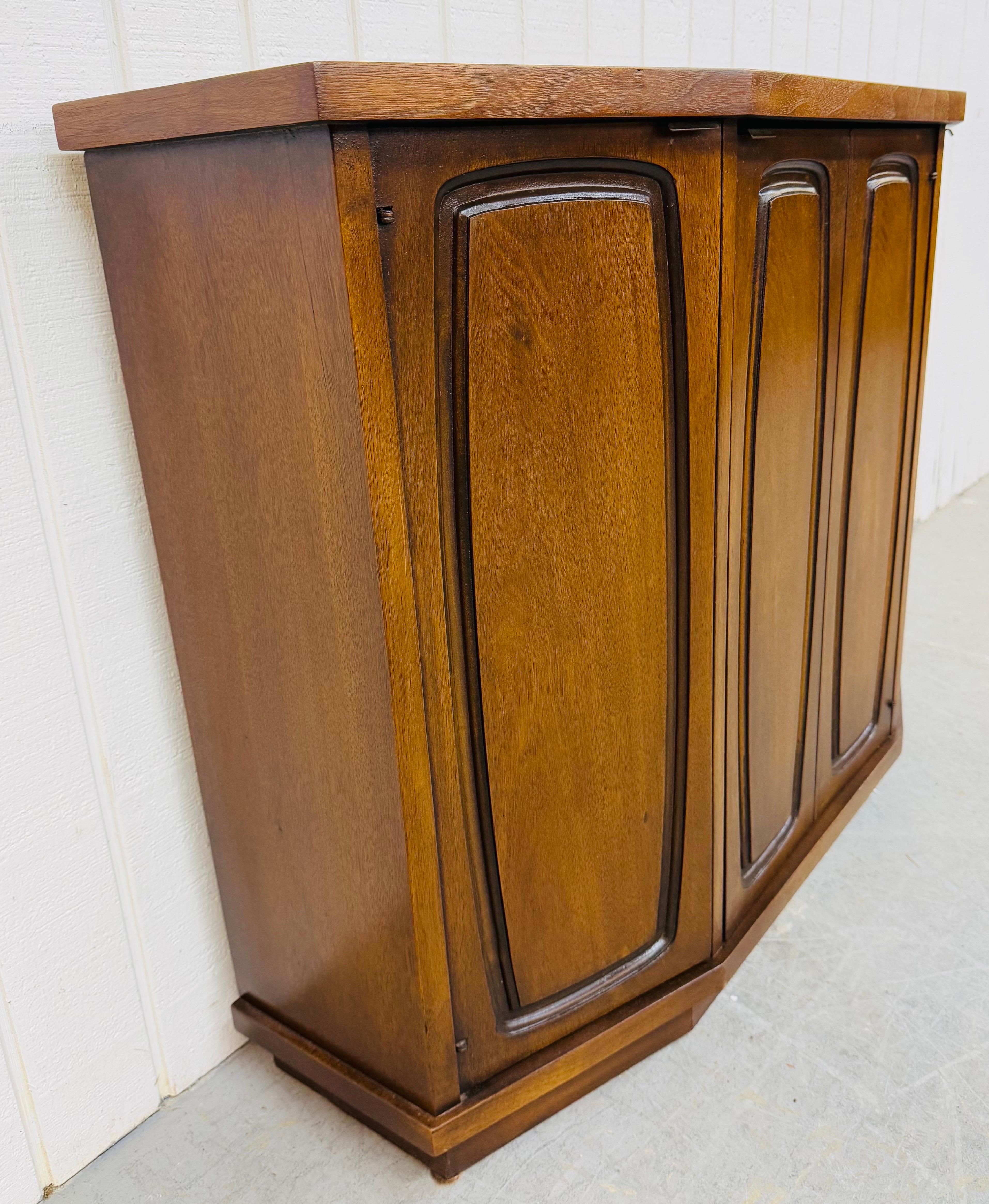 This listing is for a Mid-Century Modern Broyhill Emphasis Walnut Console. Featuring a three door design, cabinet space on the left/right side, the center opens up to a single drawer with more storage space, and a beautiful walnut finish. This is an