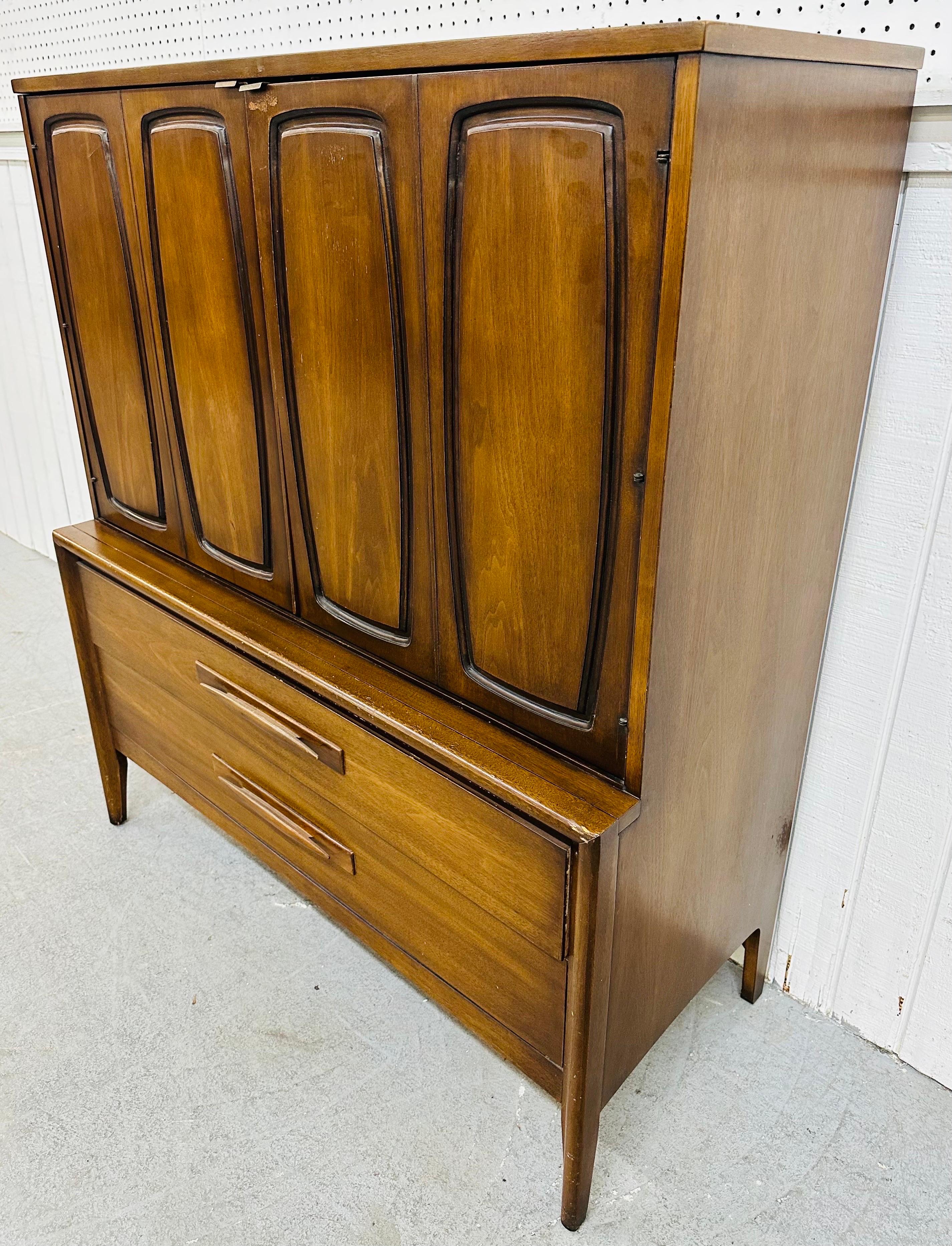 This listing is for a Mid-Century Modern Broyhill Emphasis Walnut Gentleman’s Chest. Featuring a straight line design, two large doors, with the Emphasis design, that open up to shelving and four small drawers, two large drawers at the bottom with