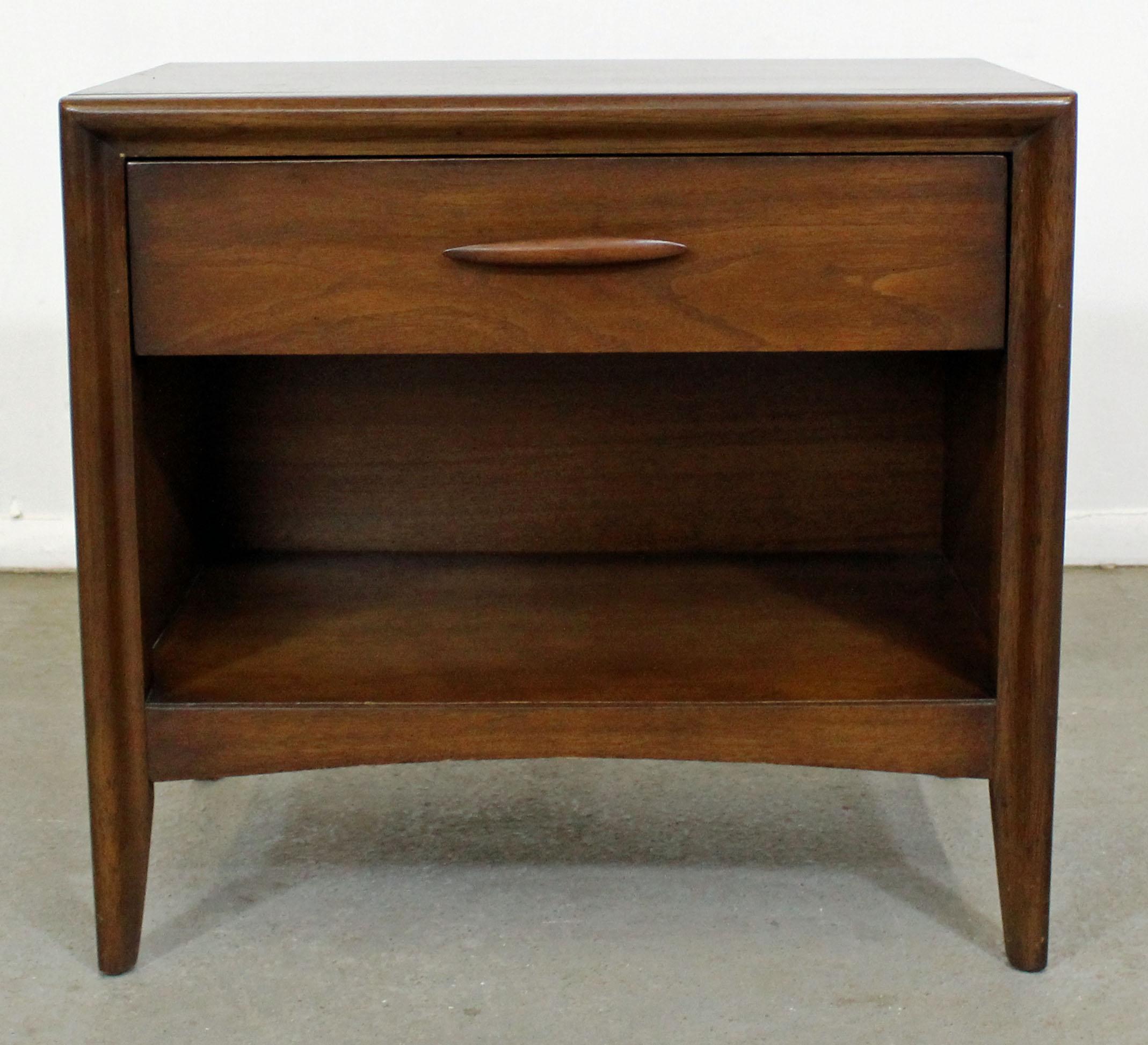 Offered is a pair of vintage 1960s Broyhill Emphasis nightstands. They are made of walnut, each featuring a single drawer up top with a sculpted pull. It is in good condition, showing minor age wear (surface scratches/wear, age wear-- see pictures).