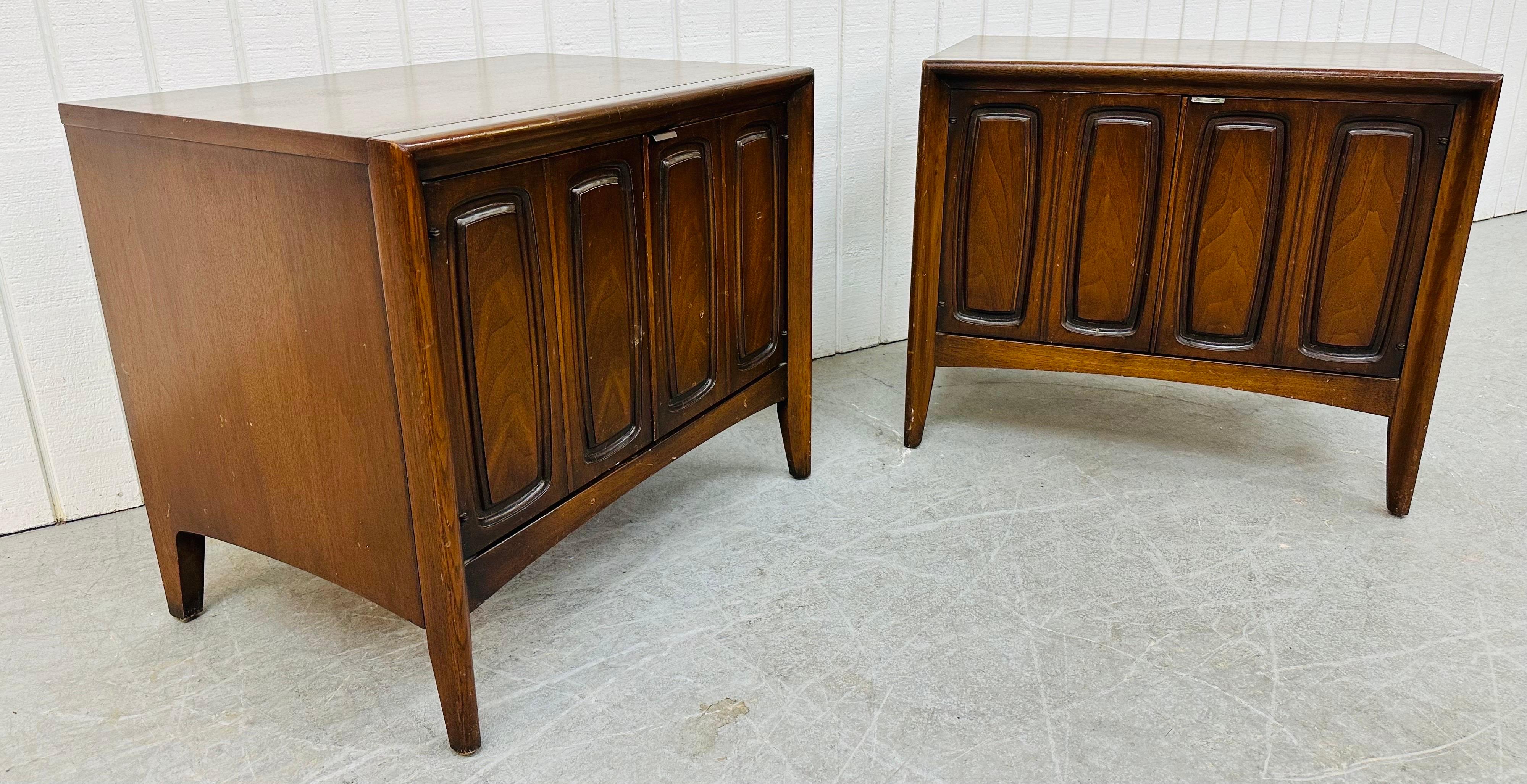 This listing is for a pair of Mid-Century Modern Broyhill Emphasis Walnut Nightstands. Featuring a straight line design, two doors with the iconic Emphasis design, interior storage space, modern legs, and a dark walnut finish. This is an exceptional