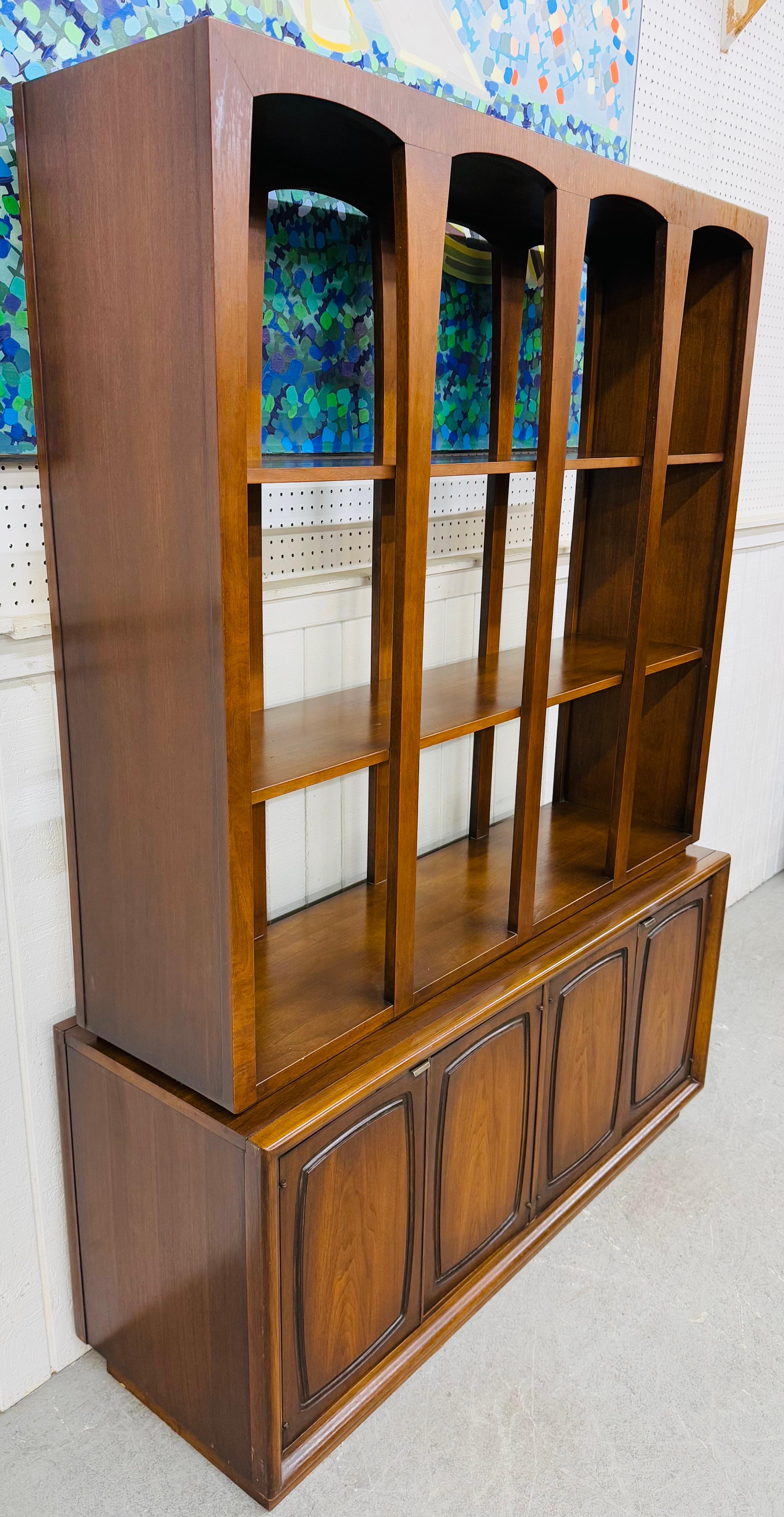 Questo annuncio si riferisce a un divisorio in due pezzi in noce di Broyhill Emphasis, un'opera moderna di metà secolo. Caratterizzato da un design lineare, due ripiani superiori, quattro ante nella parte inferiore che si aprono su cassetti e spazio