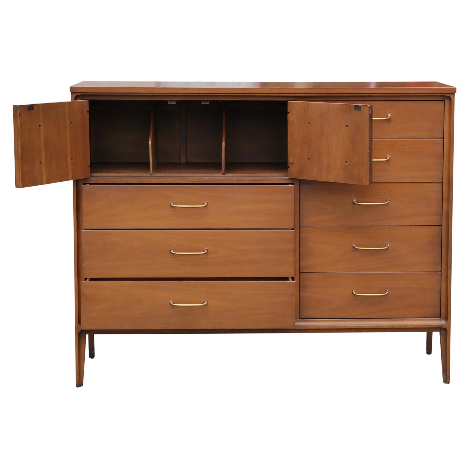 8 drawered Gentleman's chest or dresser with a swing open compartment with three storage cubbies. The dresser has the makers stamp on the inside of the top drawer.