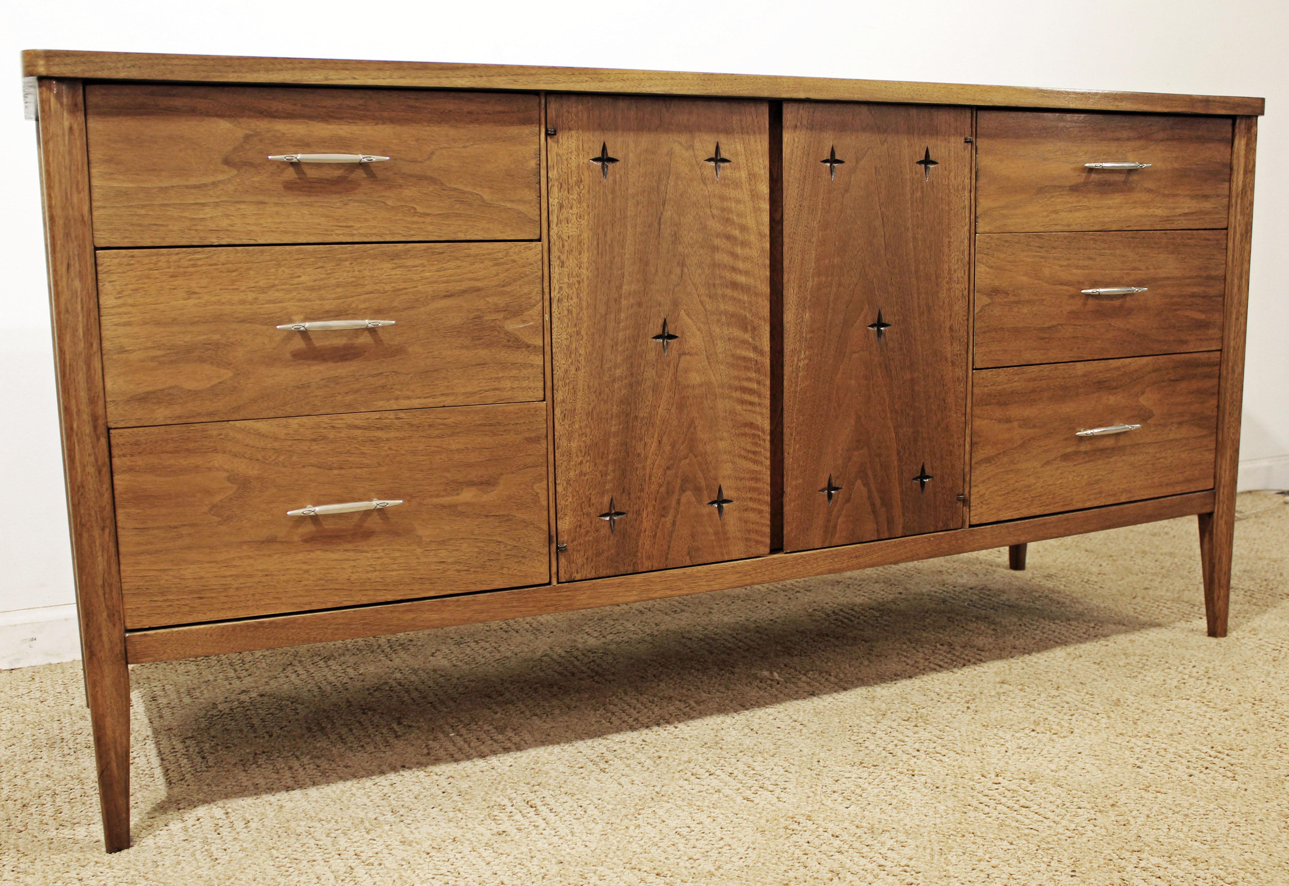 Offered is a Mid-Century Modern sculpted walnut credenza. This piece is from the 