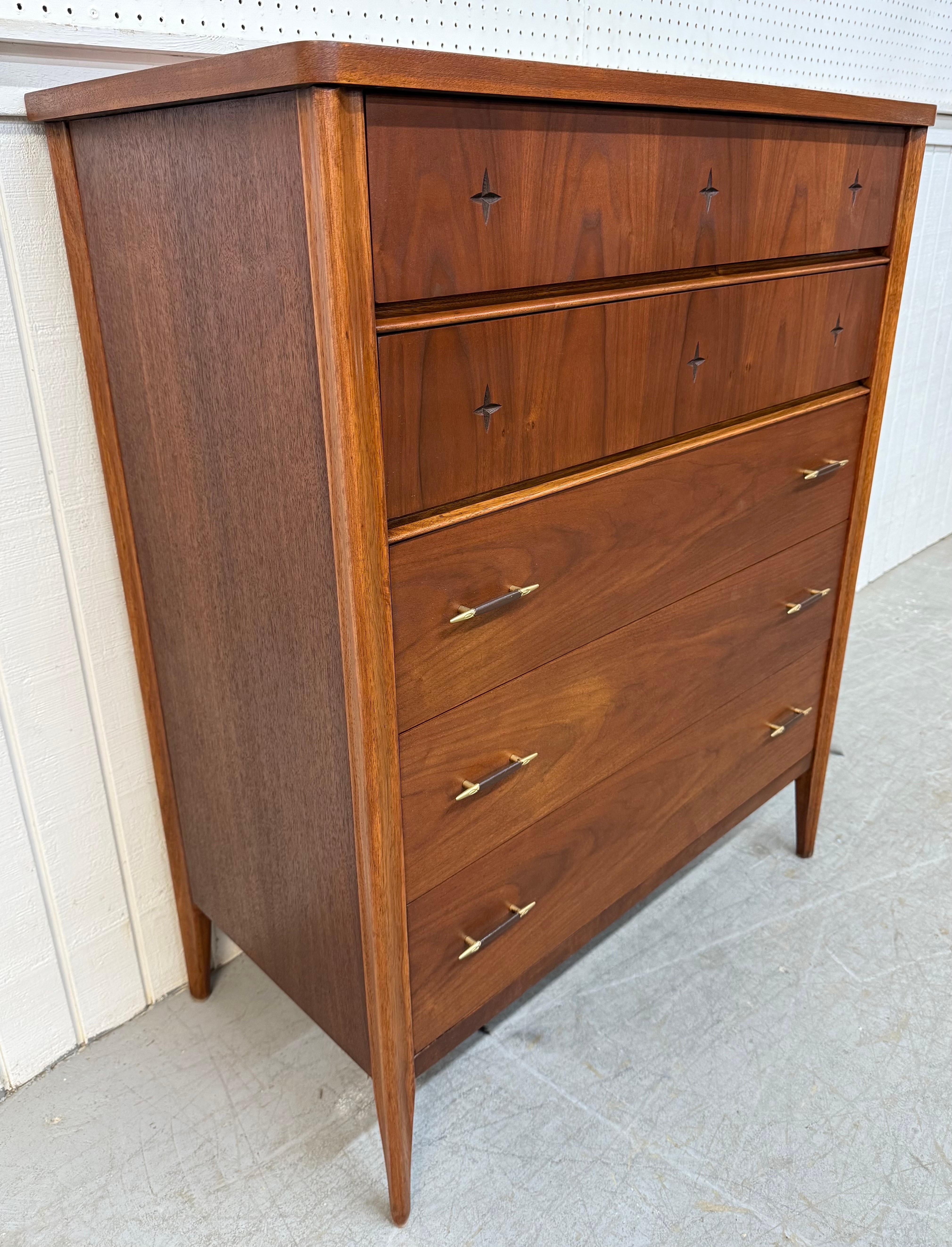 This listing is for a Mid-Century Modern Broyhill Saga Walnut High Chest. Featuring a straight line design, two top drawers with carved stars, three bottom drawers with original hardware, modern legs, and a walnut refinish. This is an exceptional