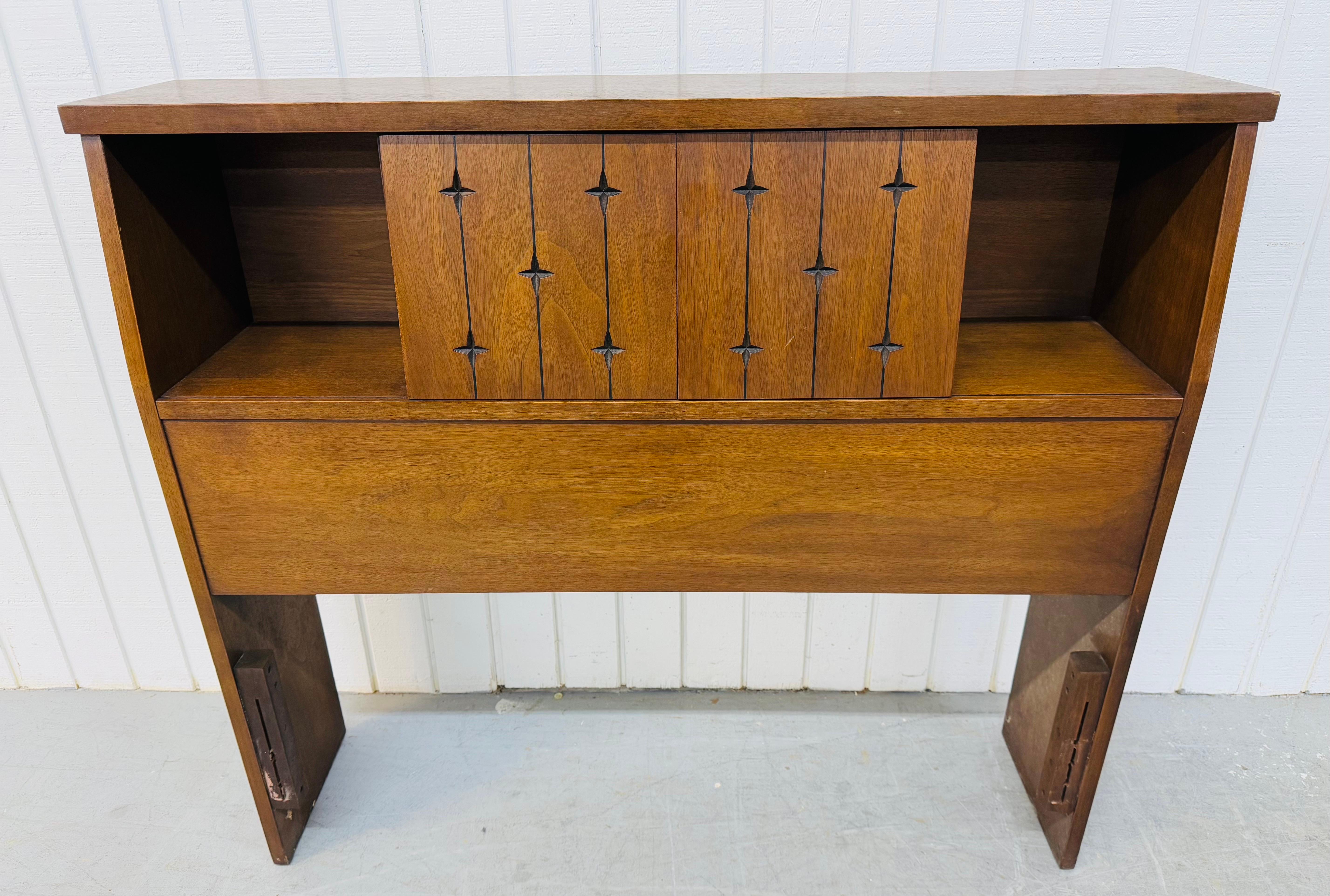 This listing is for a Mid-Century Modern Broyhill Saga Walnut Twin Size Headboard. Featuring a straight line design, sliding doors that open up to storage space, the iconic Saga carved stars, and a beautiful walnut finish. This is an exceptional