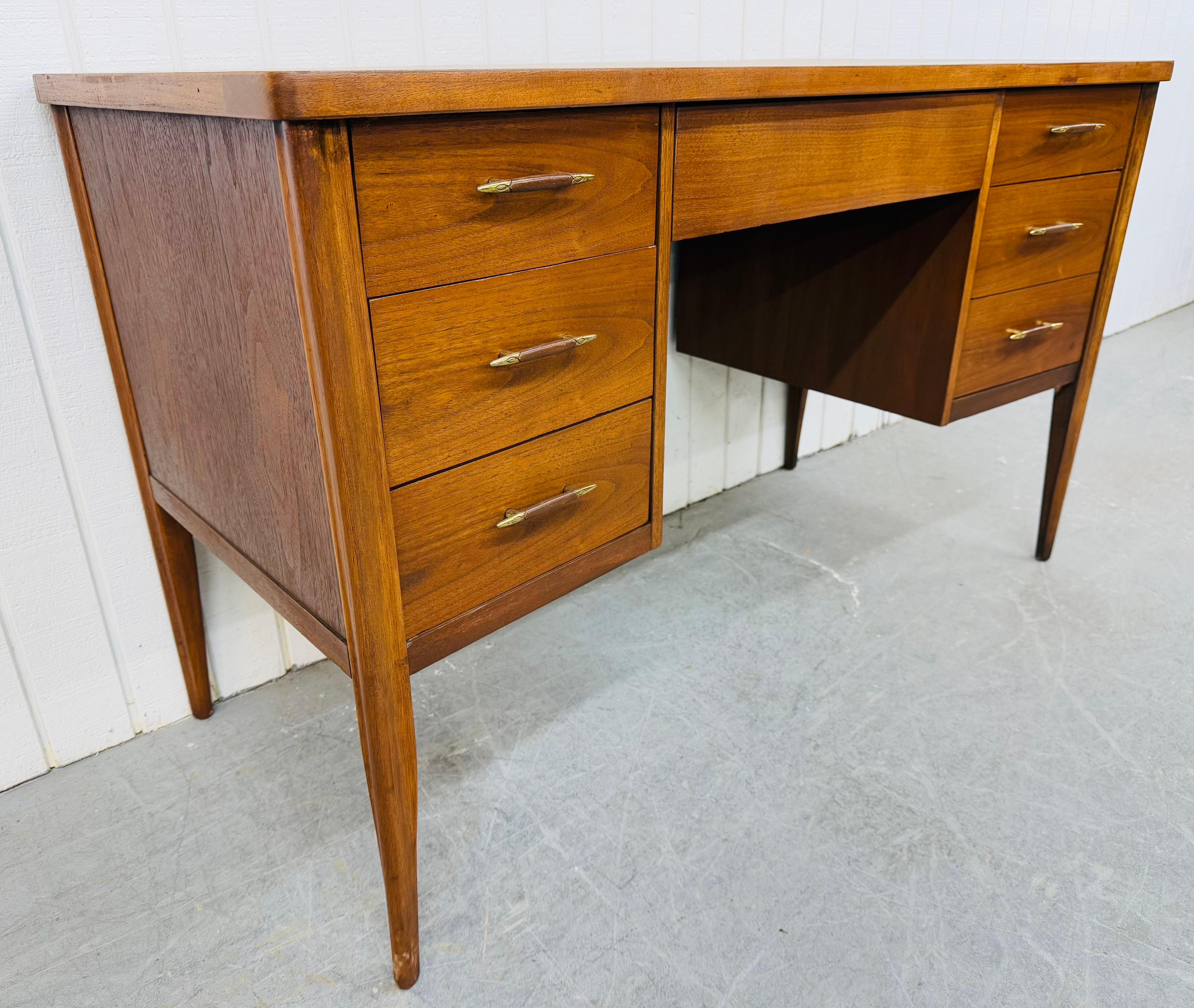 This listing is for a Mid-Century Modern Broyhill Saga Walnut Writing Desk. Featuring a straight line design, three drawers on the left, center drawer, two drawers on the right side, modern legs, finished backside, and a beautiful walnut finish.