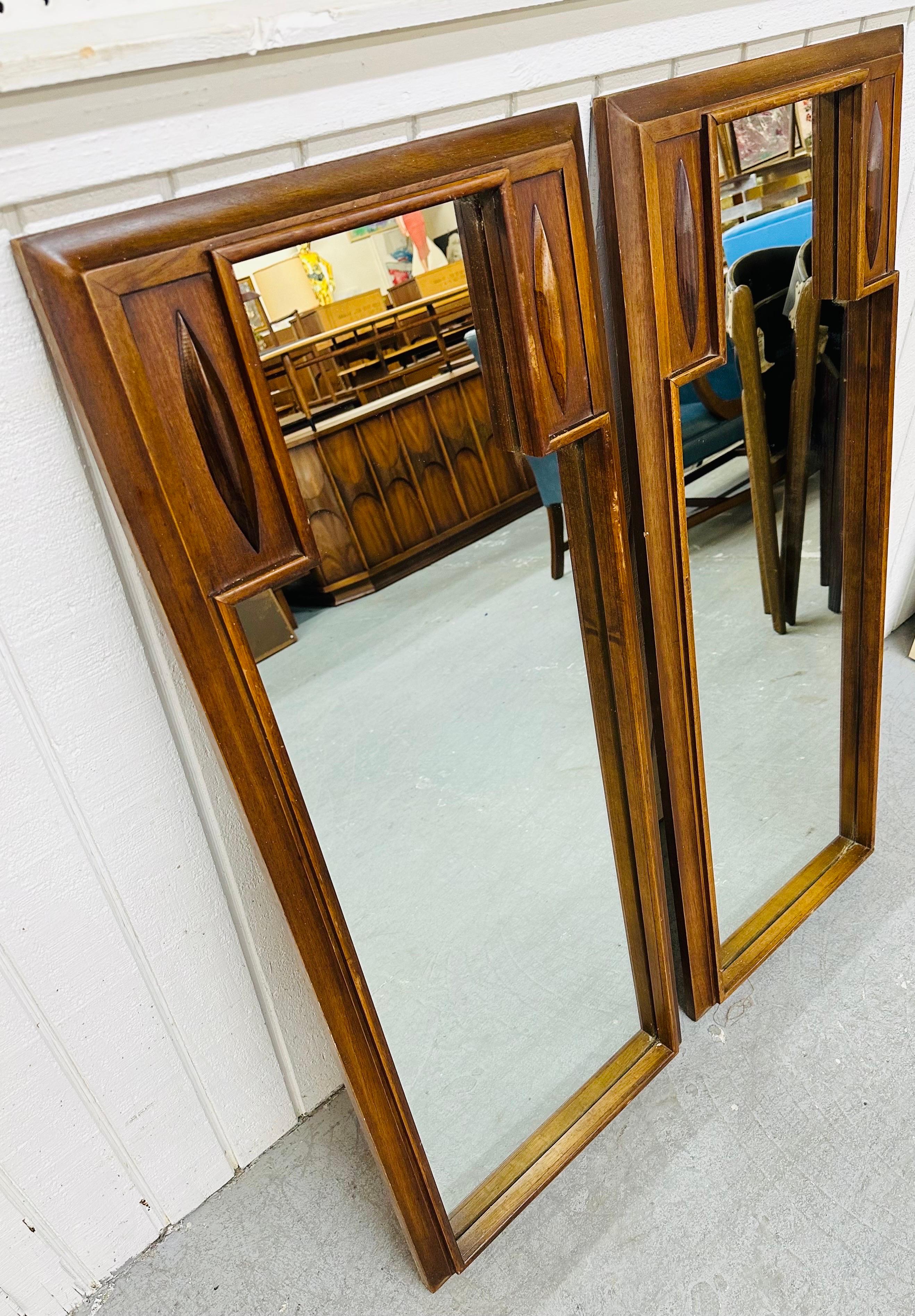This listing is for a pair of Mid-Century Modern Broyhill Sculptra Walnut Mirrors. Featuring a straight line rectangular design, the Broyhill Sculptra design in each of the top corners, a walnut frame, and original mirror. This is an exceptional