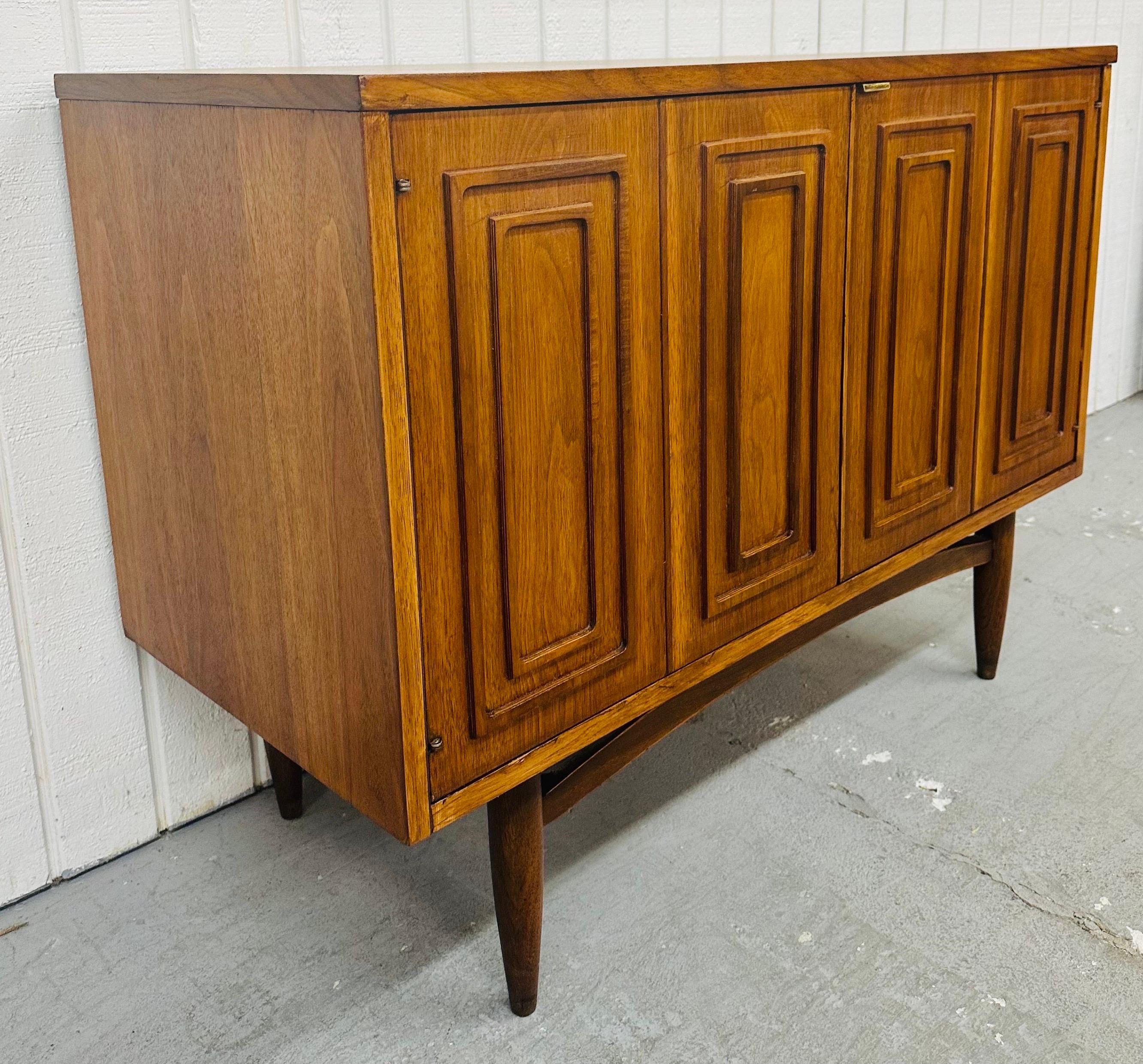This listing is for a Mid-Century Modern Broyhill Sculptra Walnut Storage Cabinet. Featuring a straight line design, two doors with brass clip pull that open up to storage space, single interior drawer, modern legs, and a beautiful walnut finish.