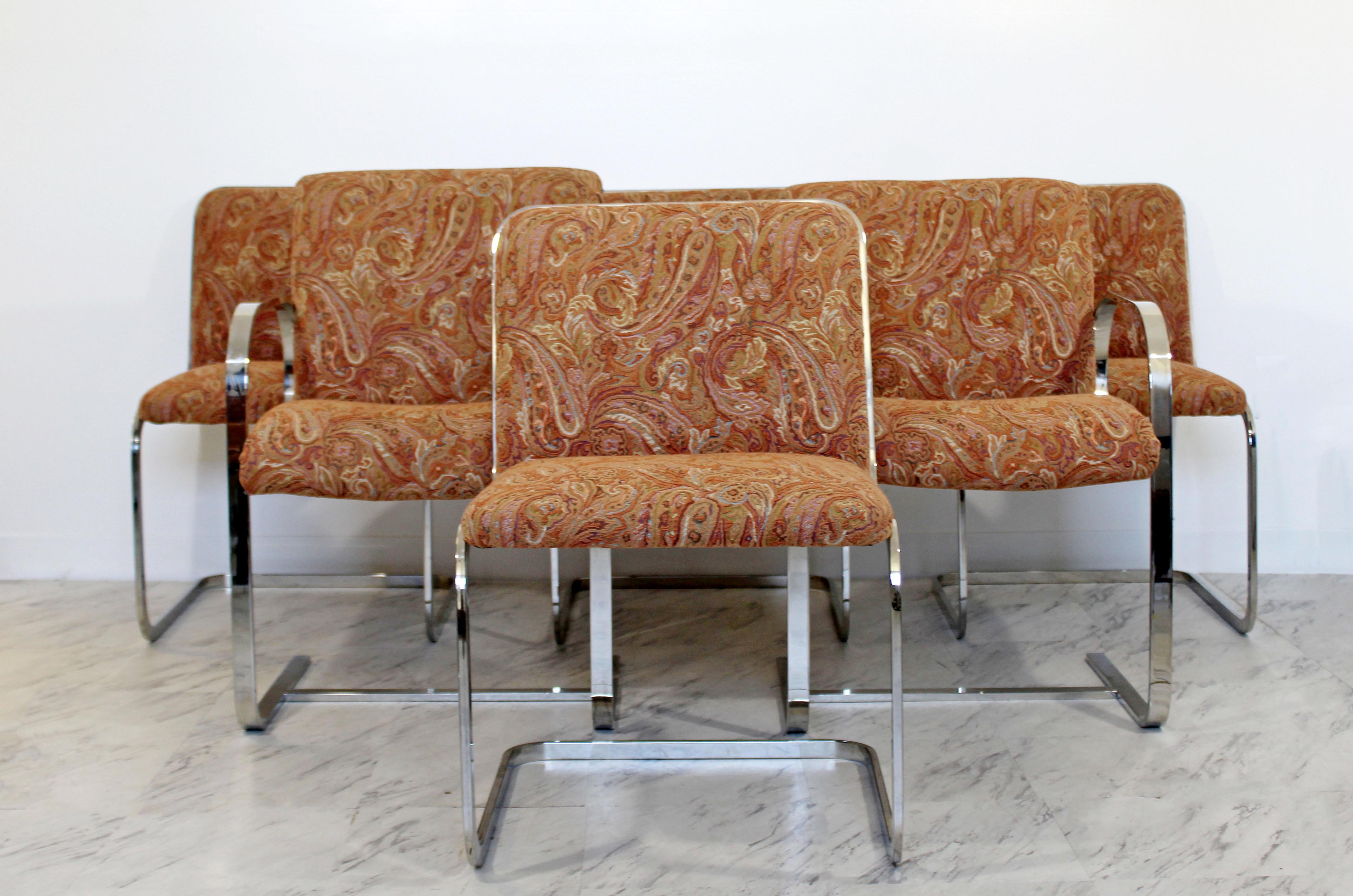 For your consideration is a stunning, set of six, cantilevered chrome dining chairs, four side and two arm, by Brueton, circa the 1960s, with a fantastic, paisley upholstery. In excellent condition. The dimensions of the armchairs are 22.5