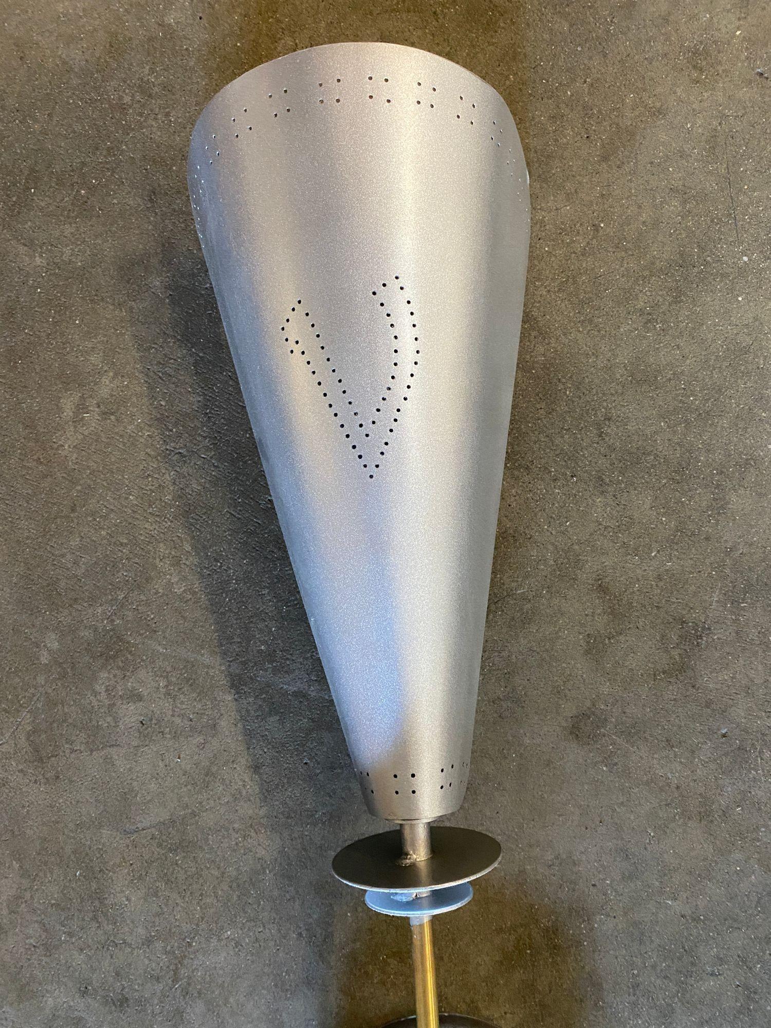 Italian brushed aluminum mid-century wall sconces with polished brash featuring a torchiere with a large folded aluminum shade connected to a brass. There is a dot pattern forming a 