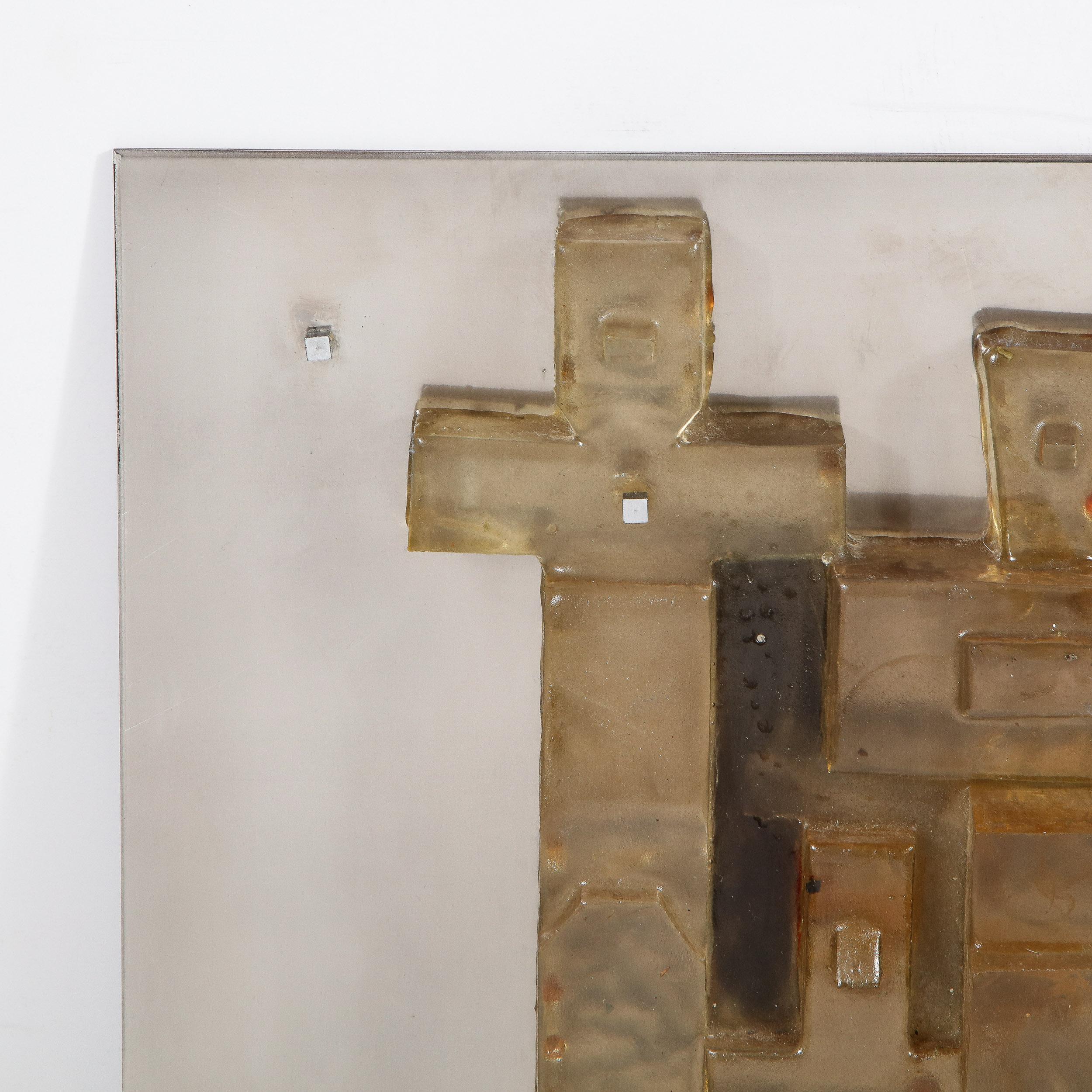 This refined Mid-Century Modern brutalist wall sculpture was realized in the United States, circa 1970. It features a patchwork mosaic of adjoined amber forms affixed to a brushed aluminum backplate. The amber shapes occupy an interesting liminal