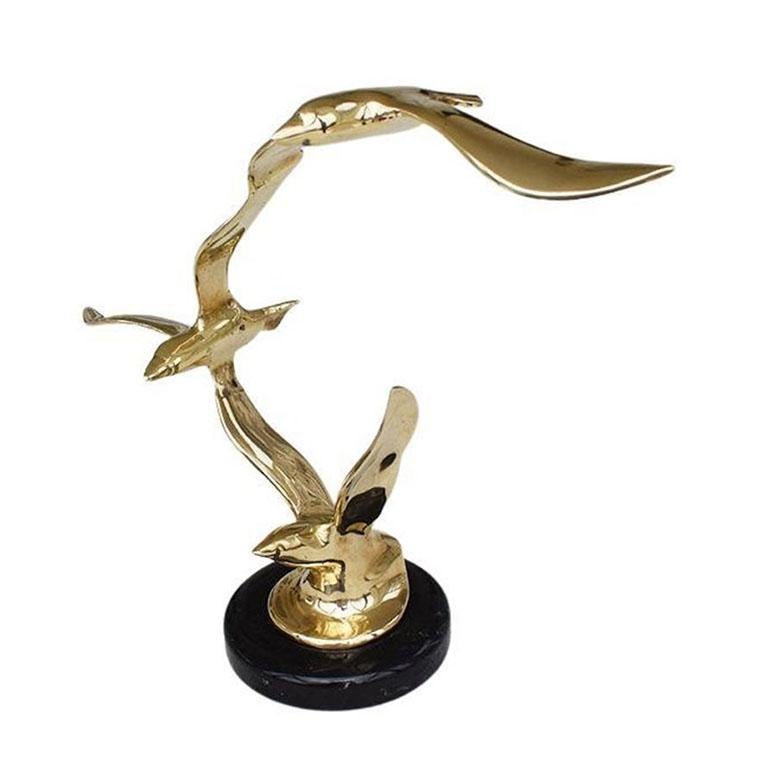 A brass and stone sculpture of birds in flight. This lovely statue is in the style of Curtis Jere. Three brass birds with wings outstretched sit upon a black stone base. A fabulous example of Brutalist Mid-Century Modern design.