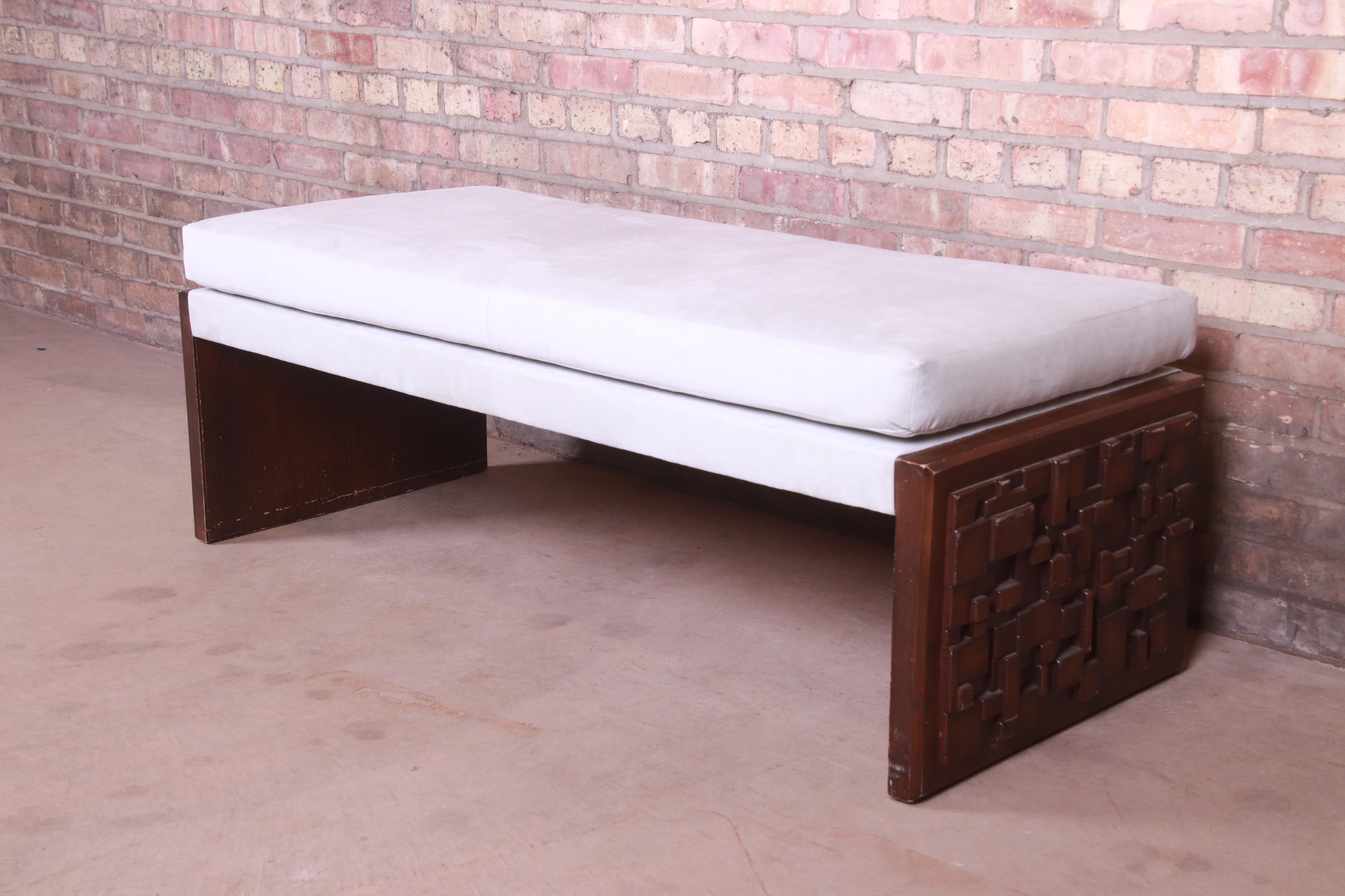A unique Mid-Century Modern brutalist bench

By Kroehler

USA, 1973

Brutalist mosaic carved walnut slab legs, with ivory microsuede upholstery.

Measures: 54
