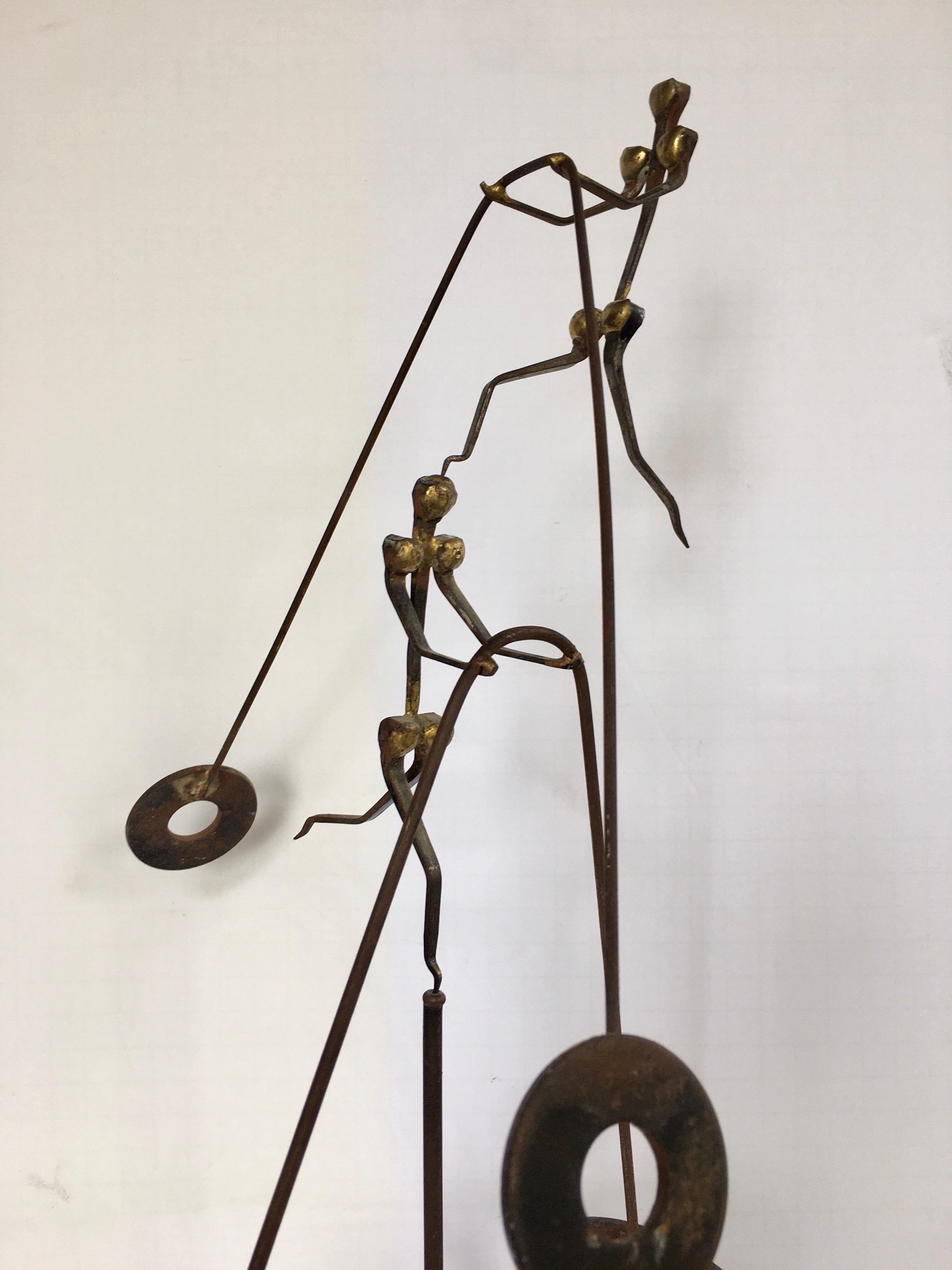 Mid-Century Modern Curtis Jere style Brutalist tabletop or book shelf counter balance sculpture constructed of welded metal and nails. This kinetic three-piece sculpture features balancing figures displayed on a tripod stand.  Signed by artist,
