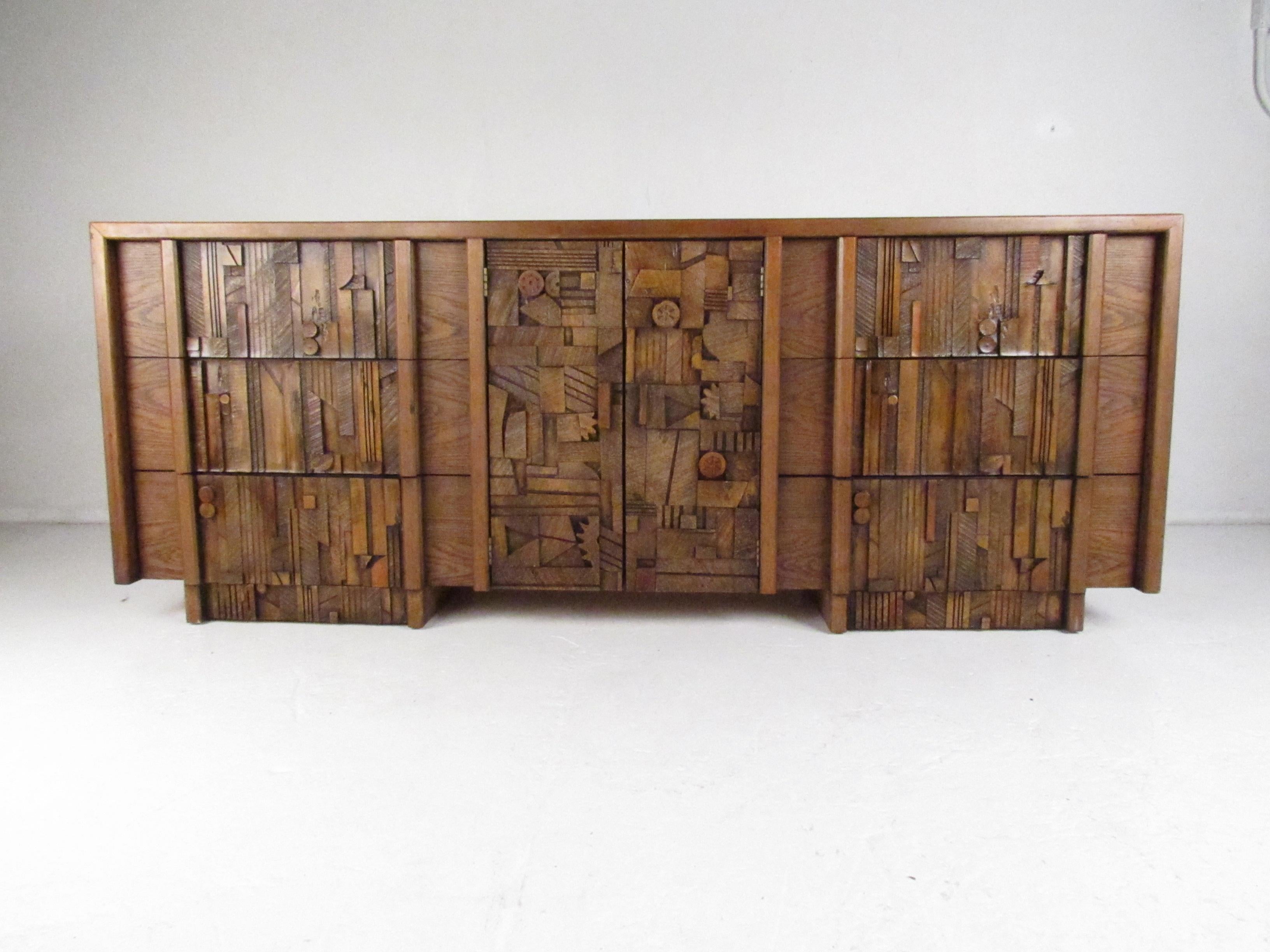 This elaborate vintage modern credenza features nine hefty drawers with colorful brutalist fronts. This sleek case piece offers plenty of room for storage without sacrificing style. A well made dresser with stunning oak wood grain throughout. Please