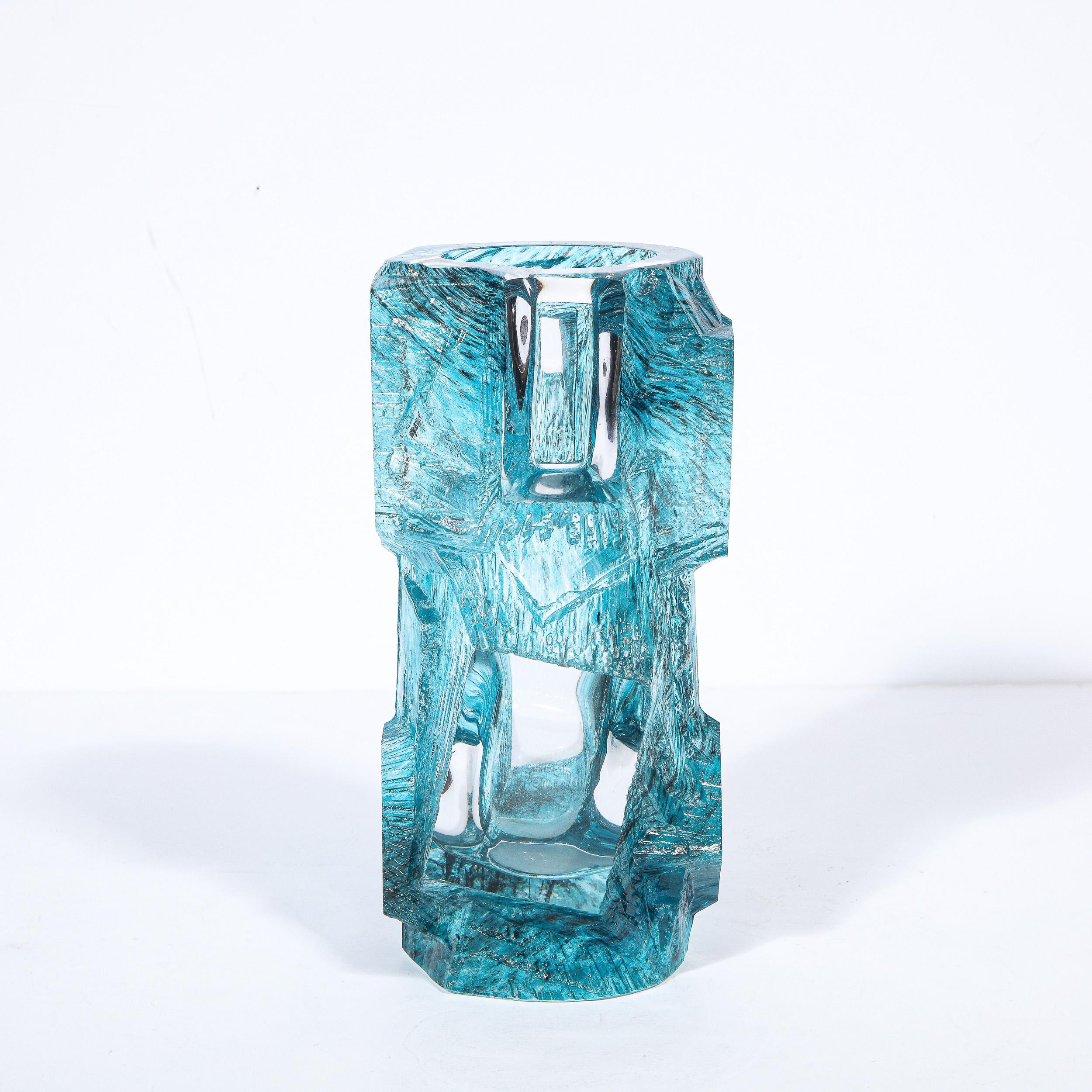 This stunning and graphic Mid-Century Modern brutalist vase was handblown by the storied atelier of Daum in Nancy, France circa 1970. It features an organic asymmetrical cylindrical body in finely striated textural sapphire blue glass. Rhombus