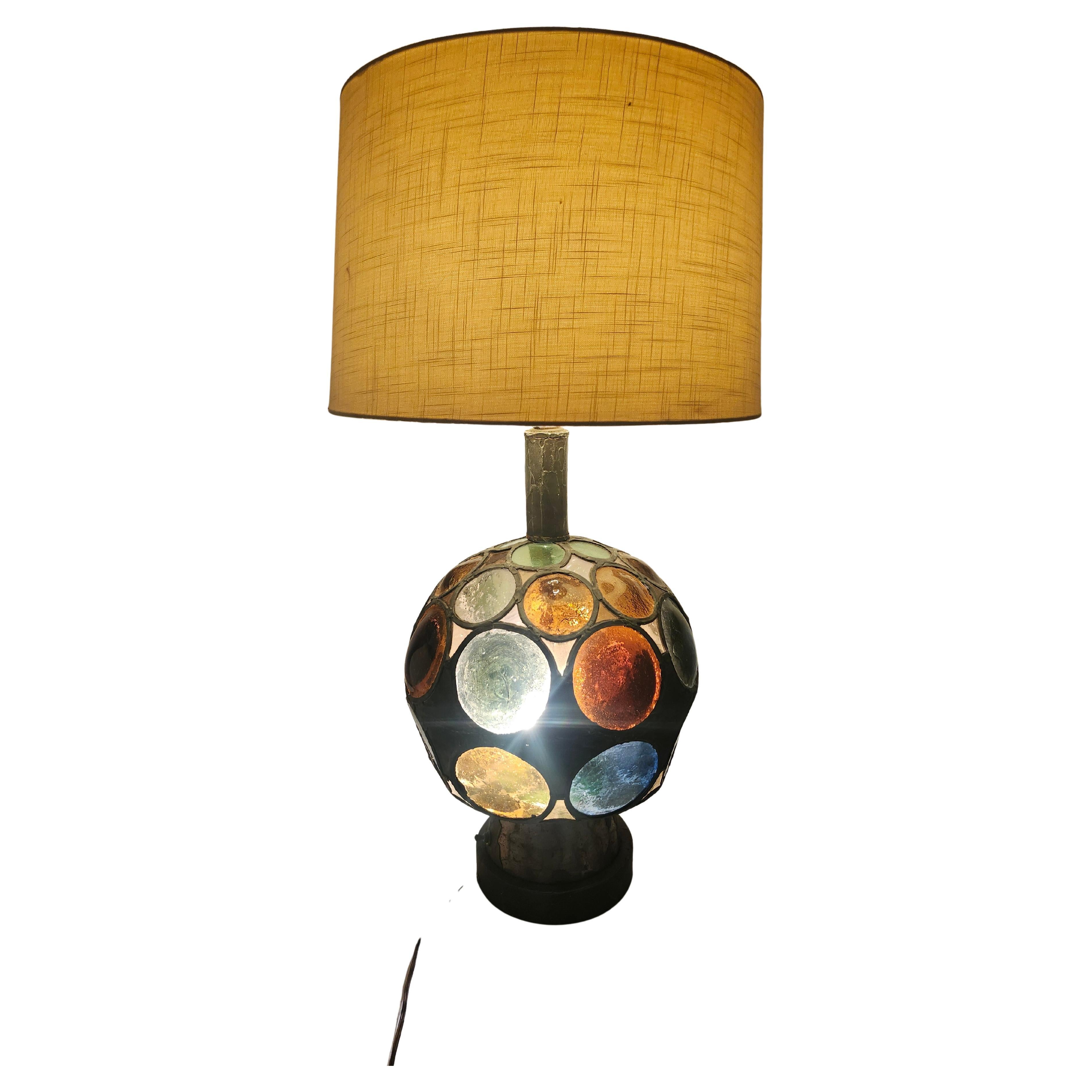 Rare et inhabituelle lampe de table brutaliste avec d'épaisses pièces de vitrail principalement rondes en conjonction avec des triangles de verre coloré et de plomb créant une grande boule de couleurs mélangées de vitrail comme une base qui s'allume