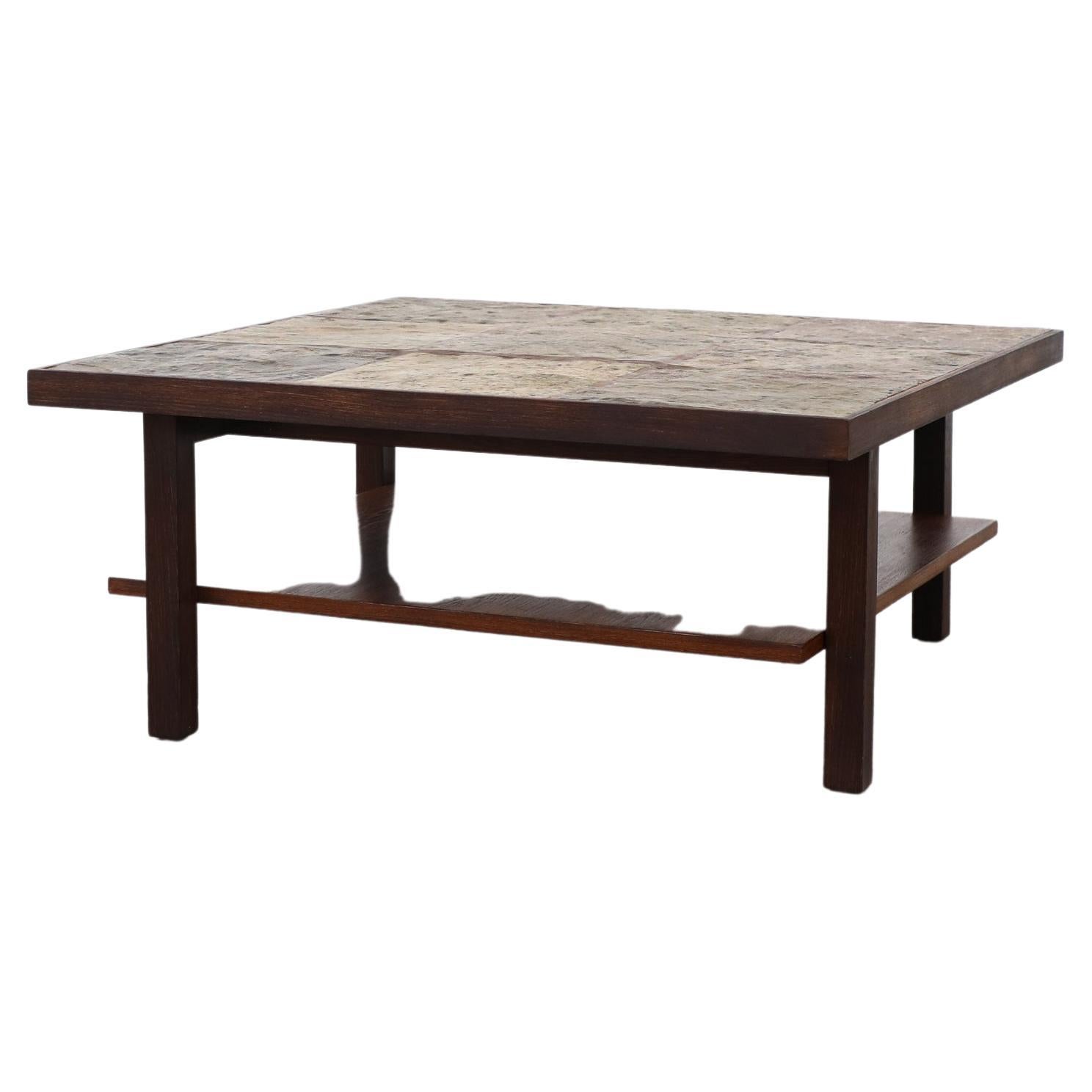 Mid-century Brutalist stone topped coffee or side table with wenge frame, lower shelf and asymmetrical legs. Earth toned slate tiles inset into a wenge frame with floating lower shelf. Lightly refinished with visible wear consistent with its age and