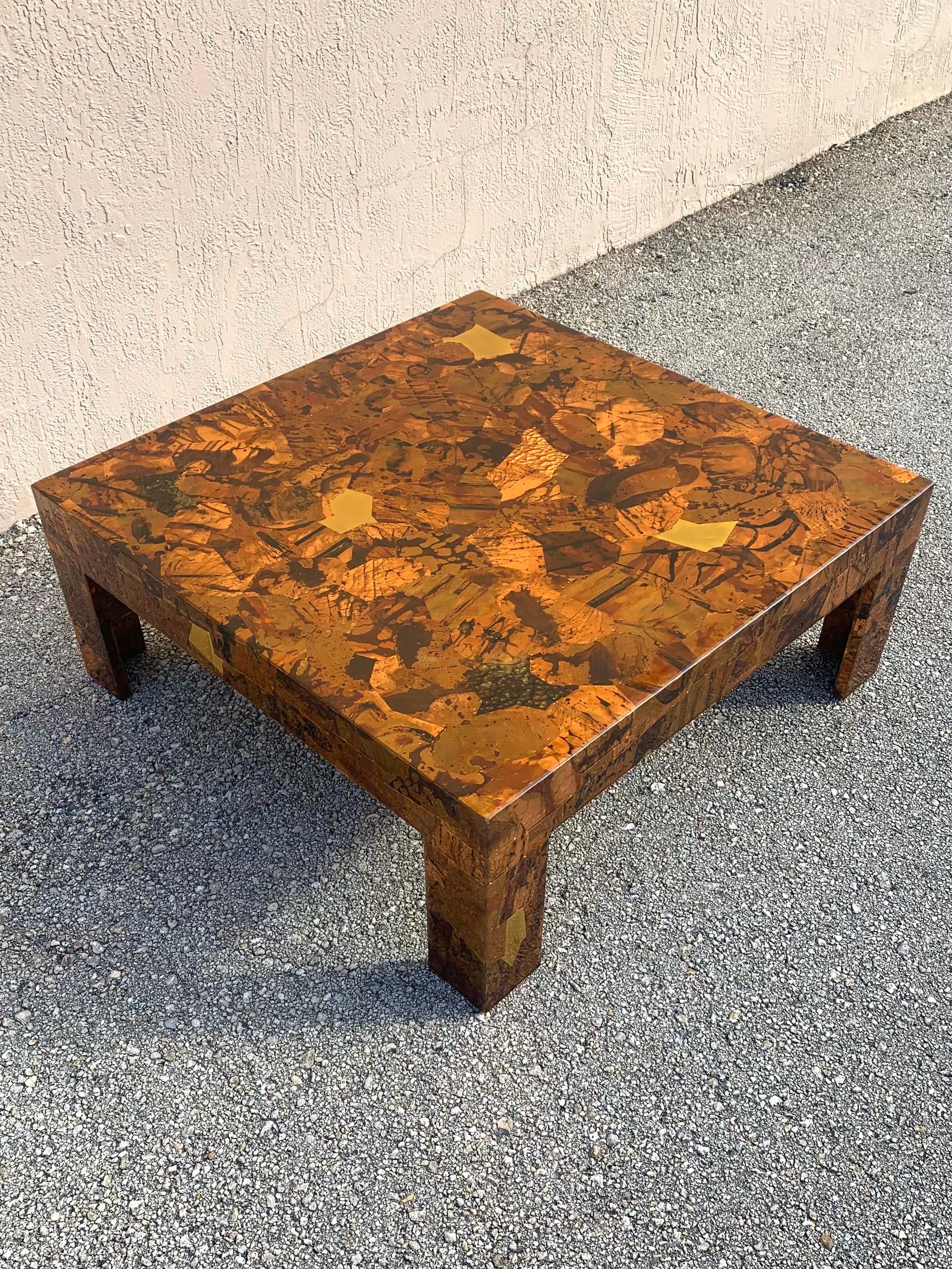 Studio made copper and brass coffee table. Made to have a brutalist flair the artist used different pieces of textured and patinated copper and clean brass to cover the entire coffee table. The plates are affixed with copper staples then covered