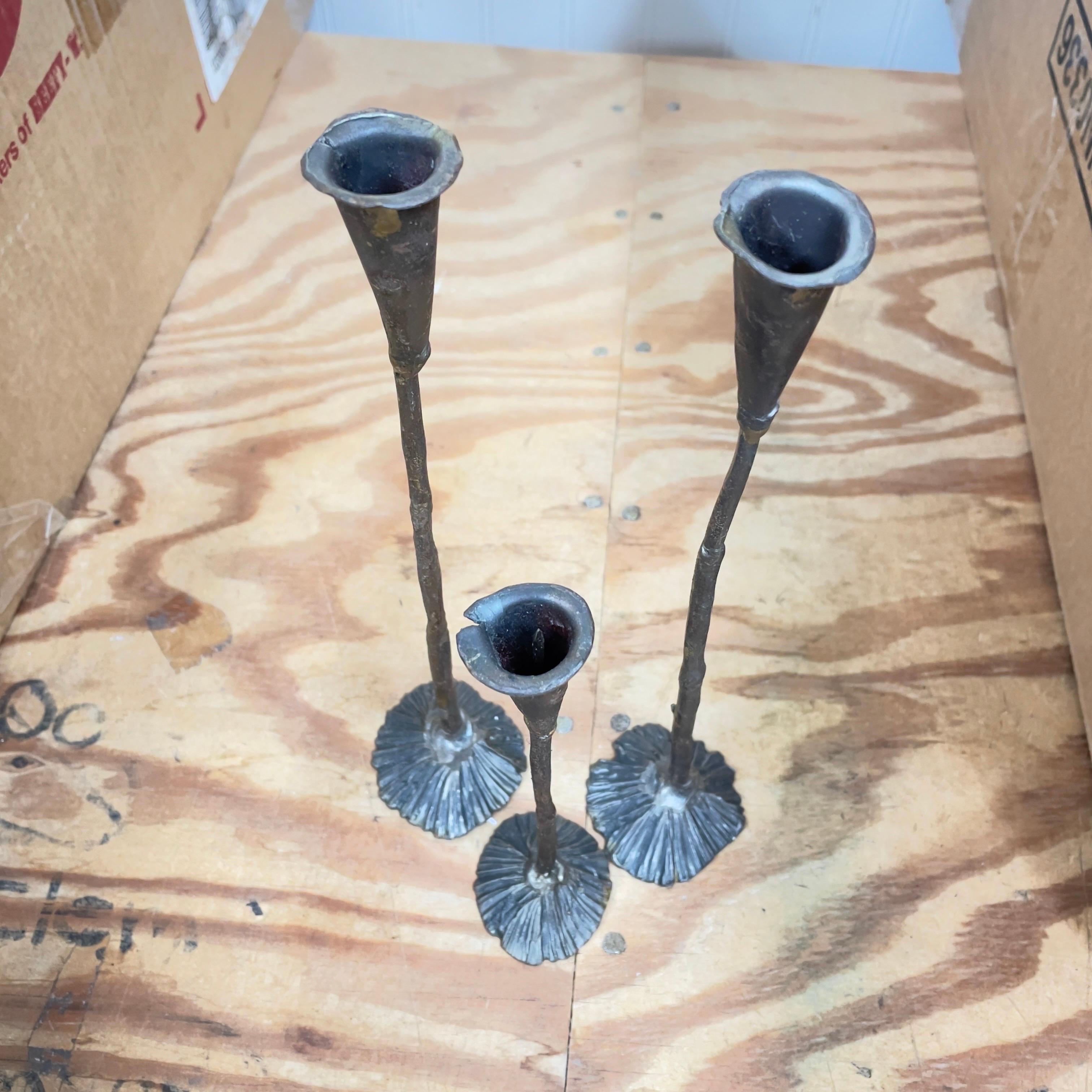 Set of three candlestick holders. Two are the same height and one is much shorter than the matching pair. Unusual brutalist style. Appears to be hand forged. 