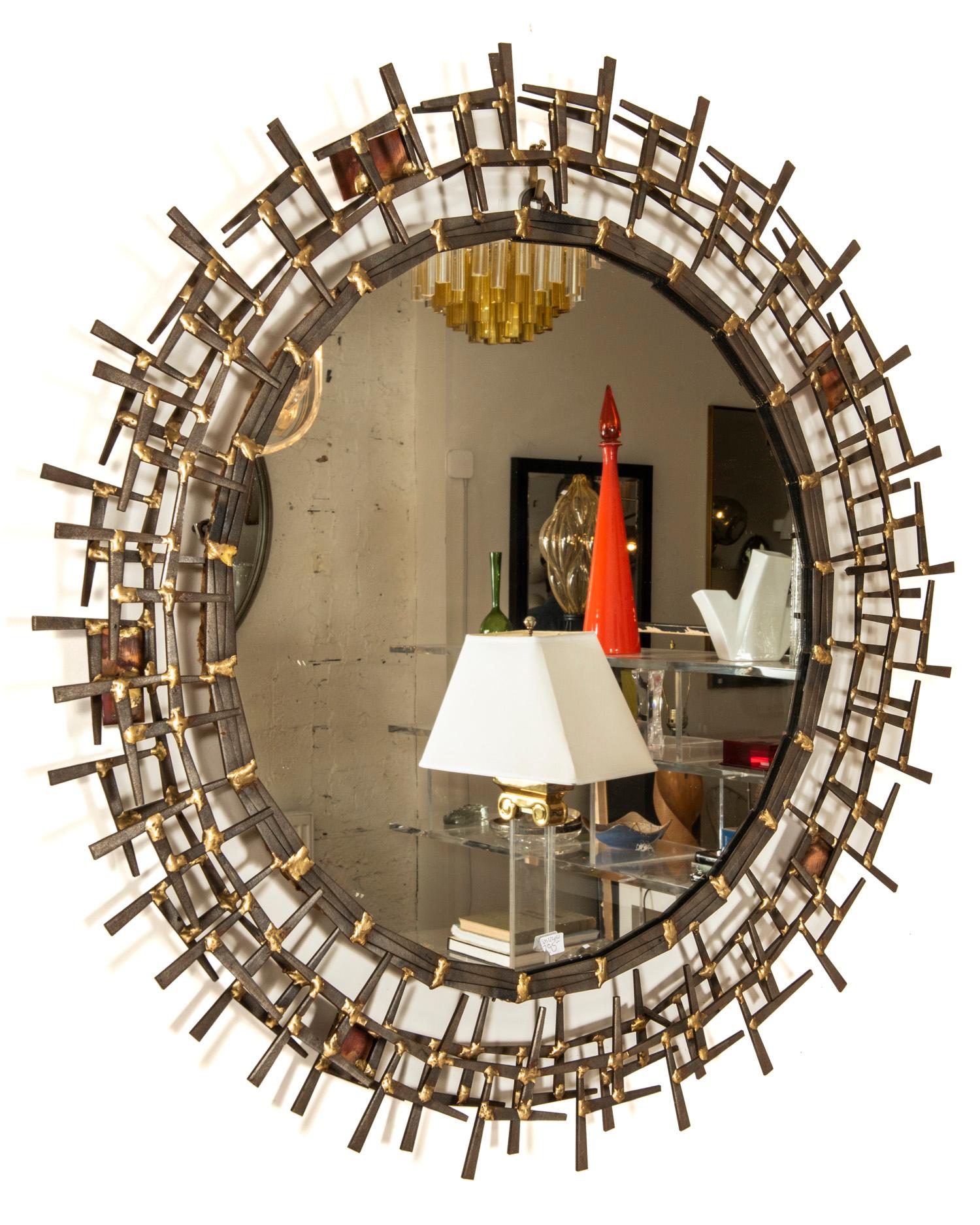 A cool vintage metal sunburst style mirror with welded pieces accented with copper and gold braising!