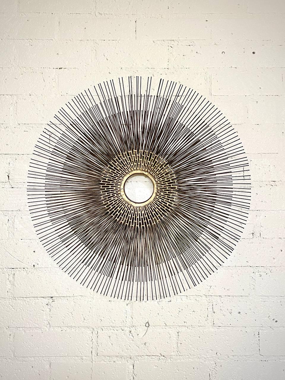 Zustand: Original Vintage By Zustand

Diese auffällige brutalistische Sunburst-Wandskulptur von William Friedle fängt die Essenz des Mid-Century Modern Designs mit einer dynamischen Anordnung von strahlenden Messingstäben ein. Sie wurde in den