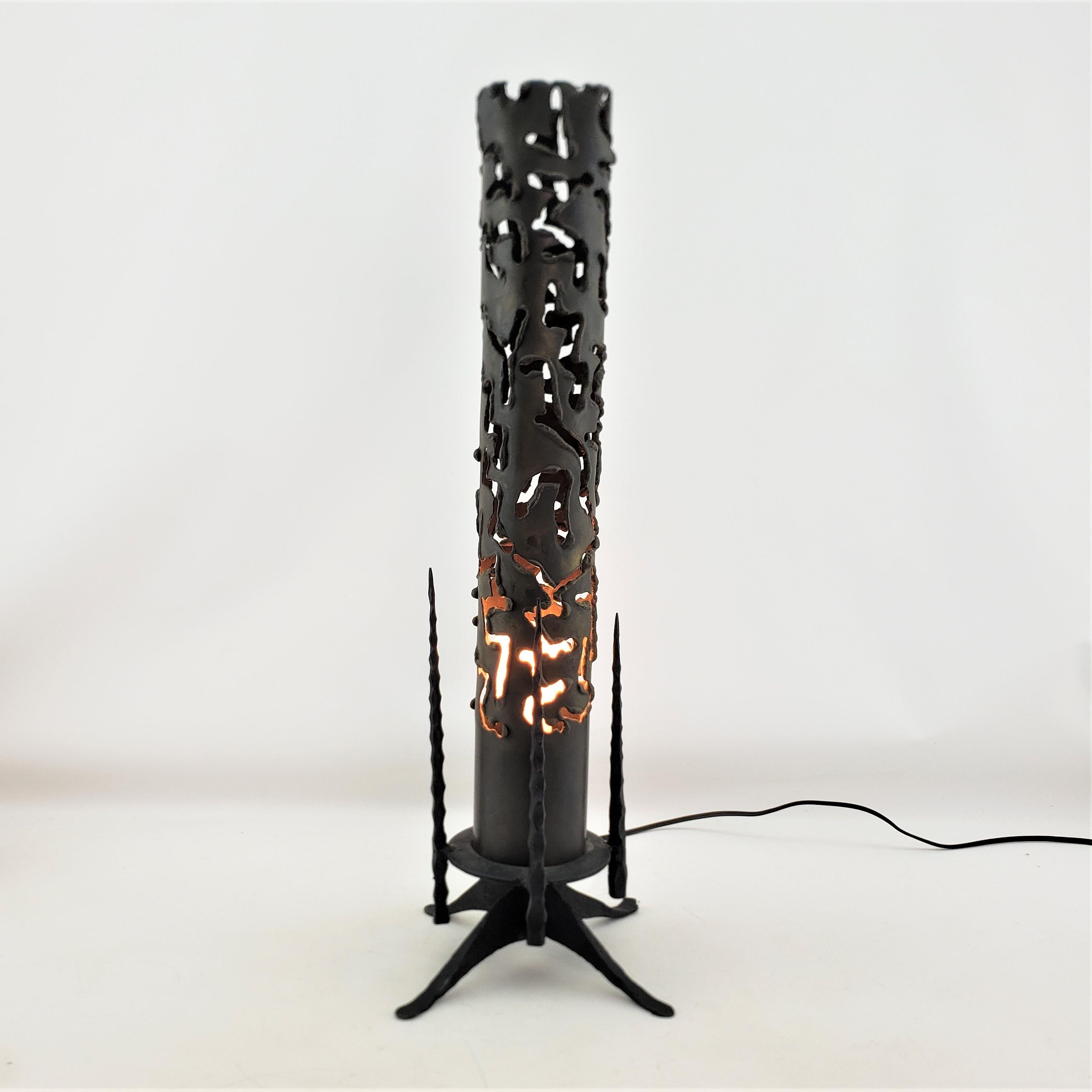 This hand-crafted table lamp or accent light is unsigned, but presumed to have originated from the United States and date to approximately 1965 and done in the period Brutalist style. The lamp is composed of heavy steel featuring a thick torch cut