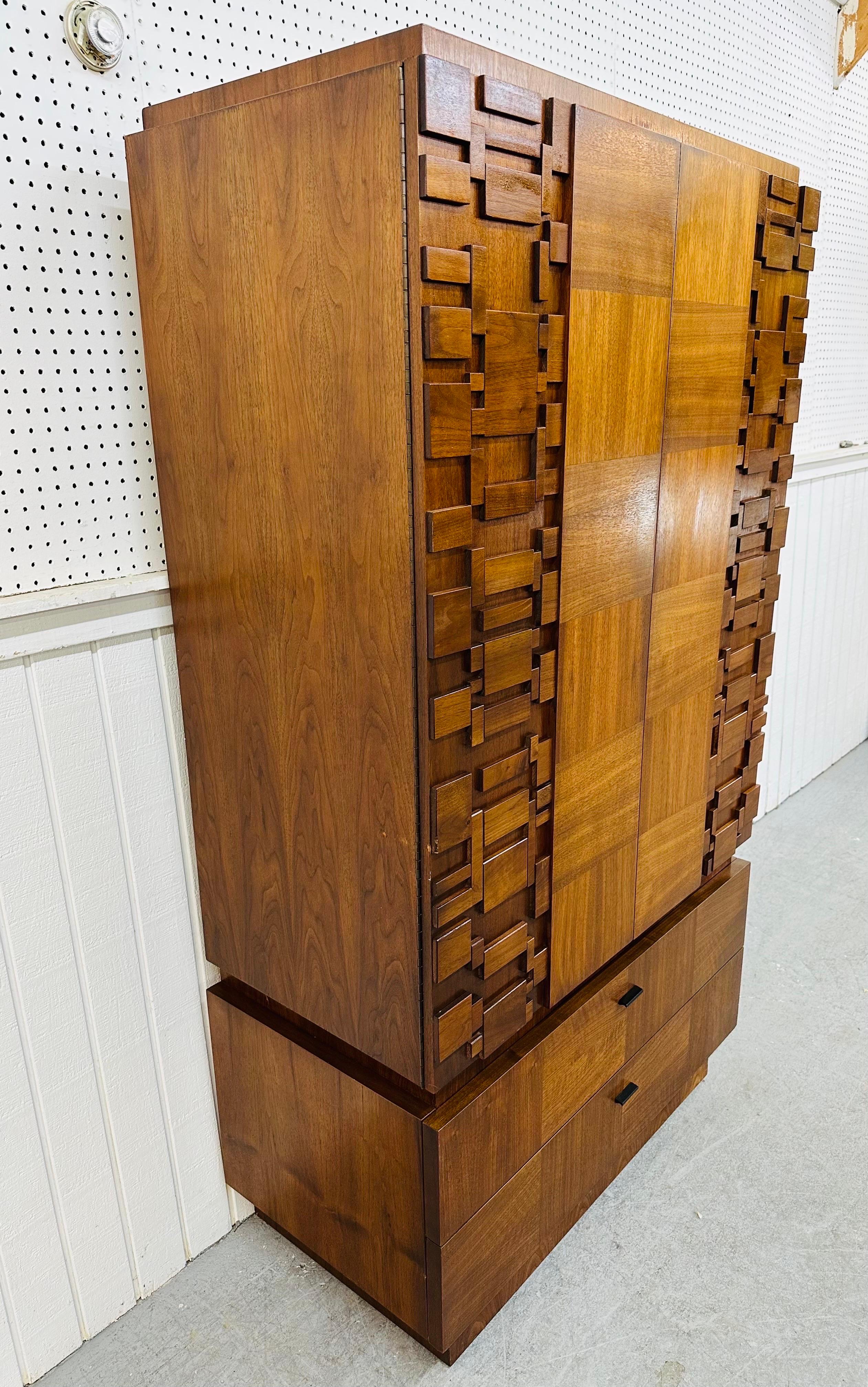 This listing is for a Mid-Century Modern Brutalist Walnut Armoire. Featuring a straight line design, two large brutalist block front designed doors that open up to storage space, three hidden drawers, two larger drawers at the bottom, original black