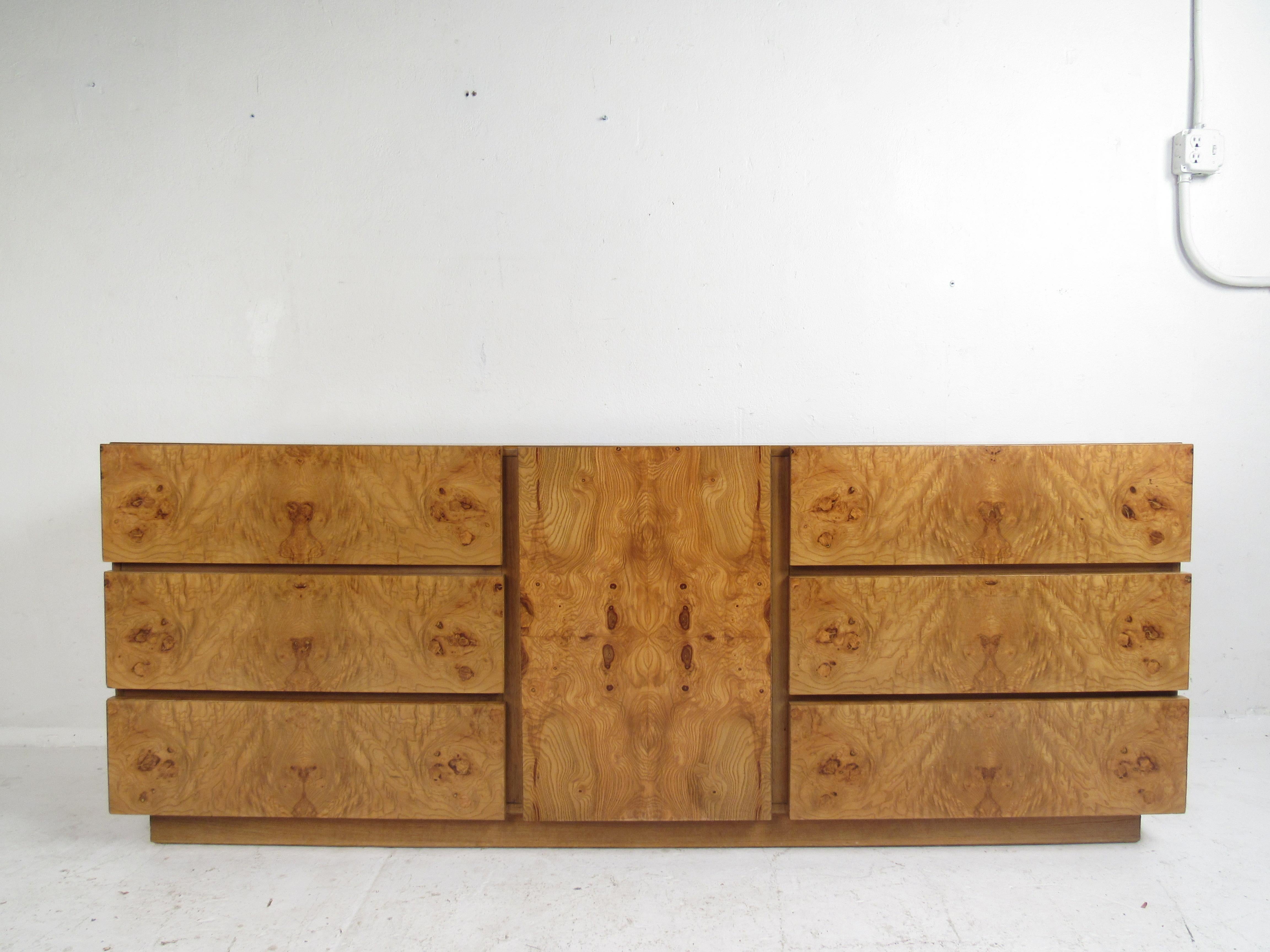 This impressive vintage modern bedroom set includes a highboy dresser and a low dresser. Well-made case pieces with straight lines and elegant burl wood grain throughout. A gently used set that has a large wardrobe/armoire with a storage compartment