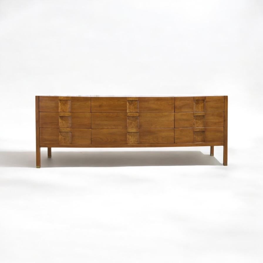 This is a mid-century modern burlwood credenza by Lane Furniture. I particularly like the scale. With an imposing 80 inch length and elongated brass capped legs, this piece makes a strong decorating statement. The drawers have burned fronts. The