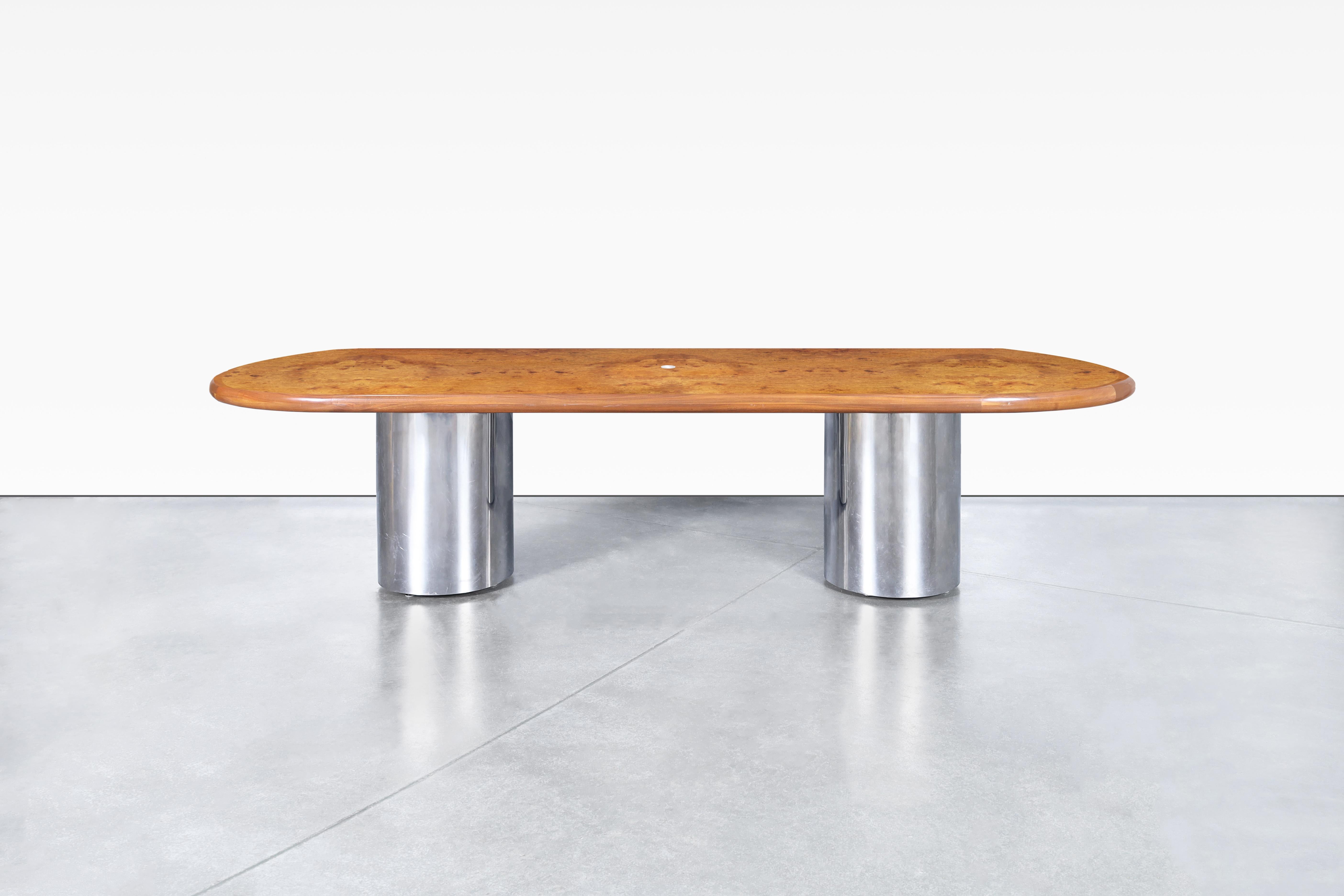 Beautiful mid-century modern burl wood and chrome oval dining table, designed in the United States, circa 1970s. Experience the epitome of elegance with our meticulously handcrafted oval dining table, inspired by the iconic designs of the Pace