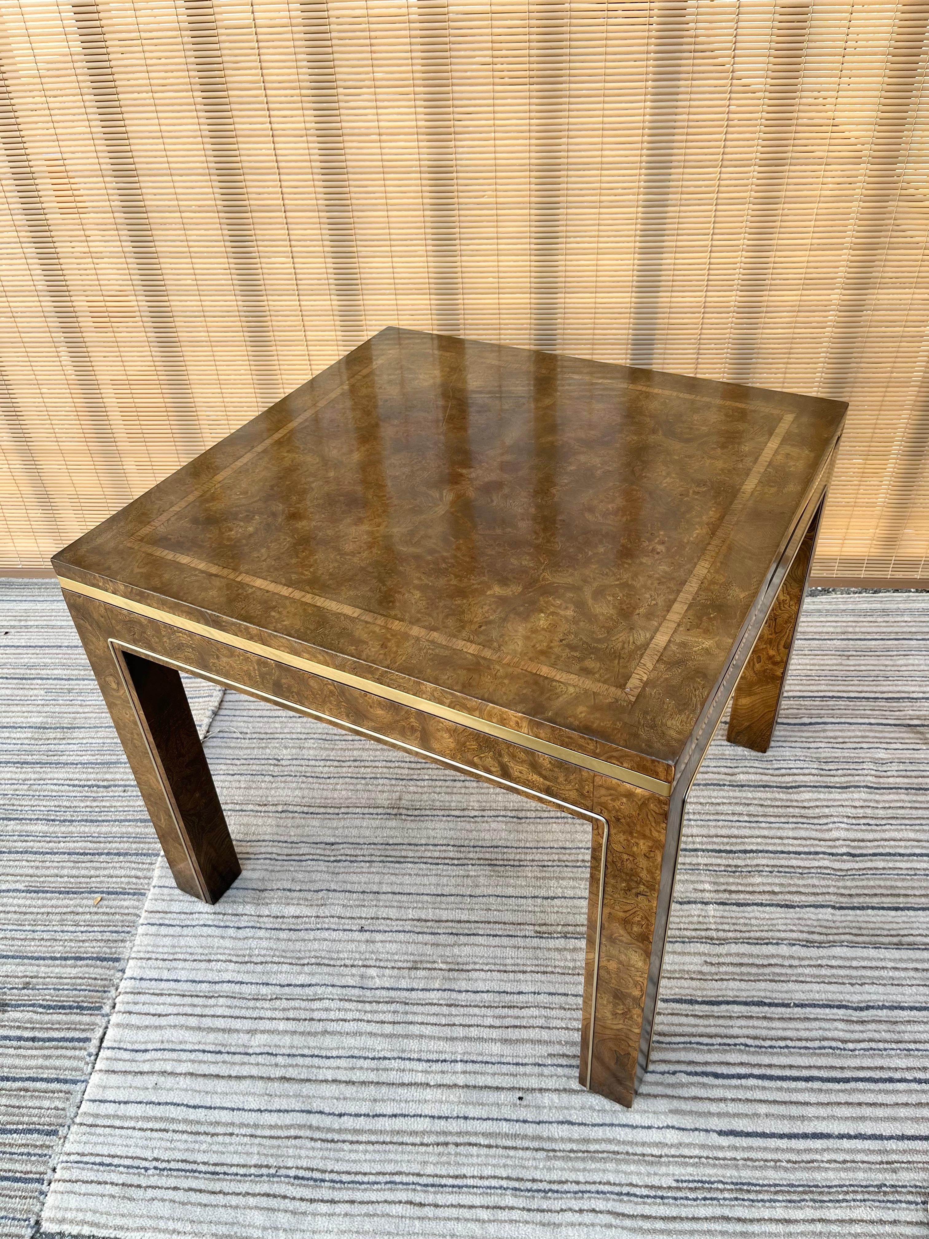 Table d'appoint en bois de ronce Vintage Mid-Century / Hollywood Regency par Mastercraft Furniture. Circa Mid 1960s .
De forme carrée et de taille moyenne, il présente une belle finition en placage de bois de ronce d'olivier et des garnitures en