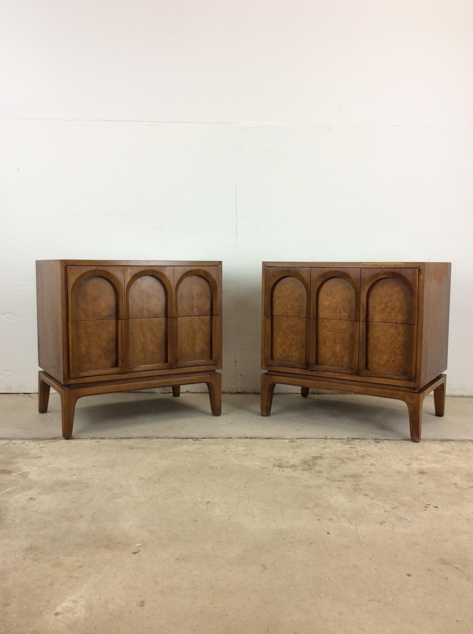 This pair of mid century modern nightstands by Thomasville features hardwood construction, beautiful burlwood veneer, two dovetailed drawers with unique arched faces, and tall tapered legs.  Matching highboy and lowboy dresser available
