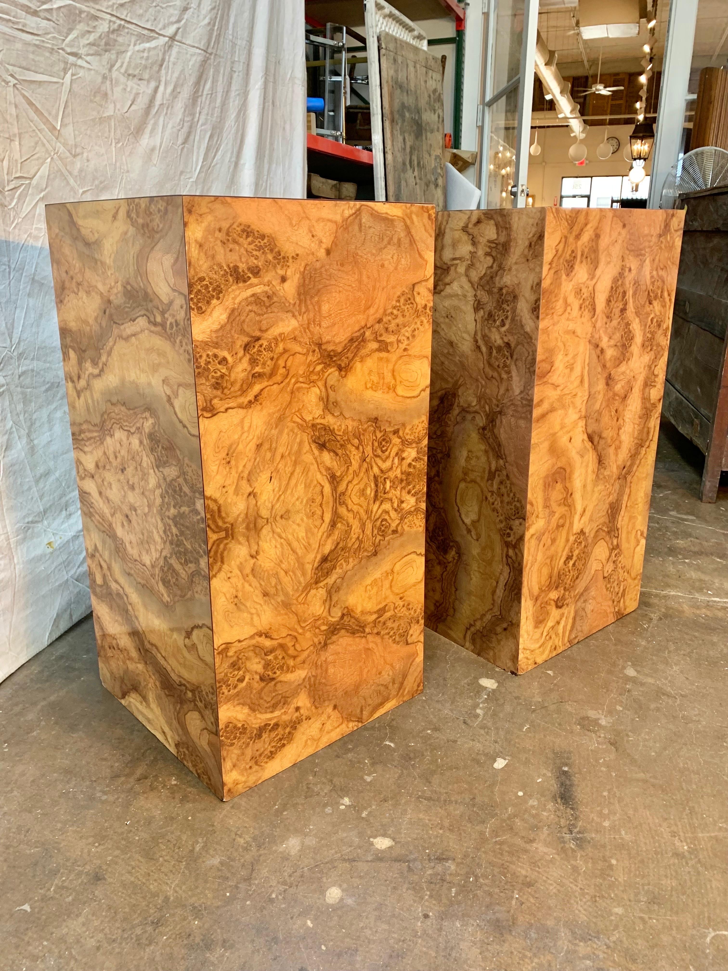 This pair of Mid Century Modern Burlwood Pedestals were crafted in the 1970's in style of Milo Baughman. Each pedestal is constructed with a burlwood veneer that has been applied to a pressed wood substrate. A unique pair, these pedestals with thier