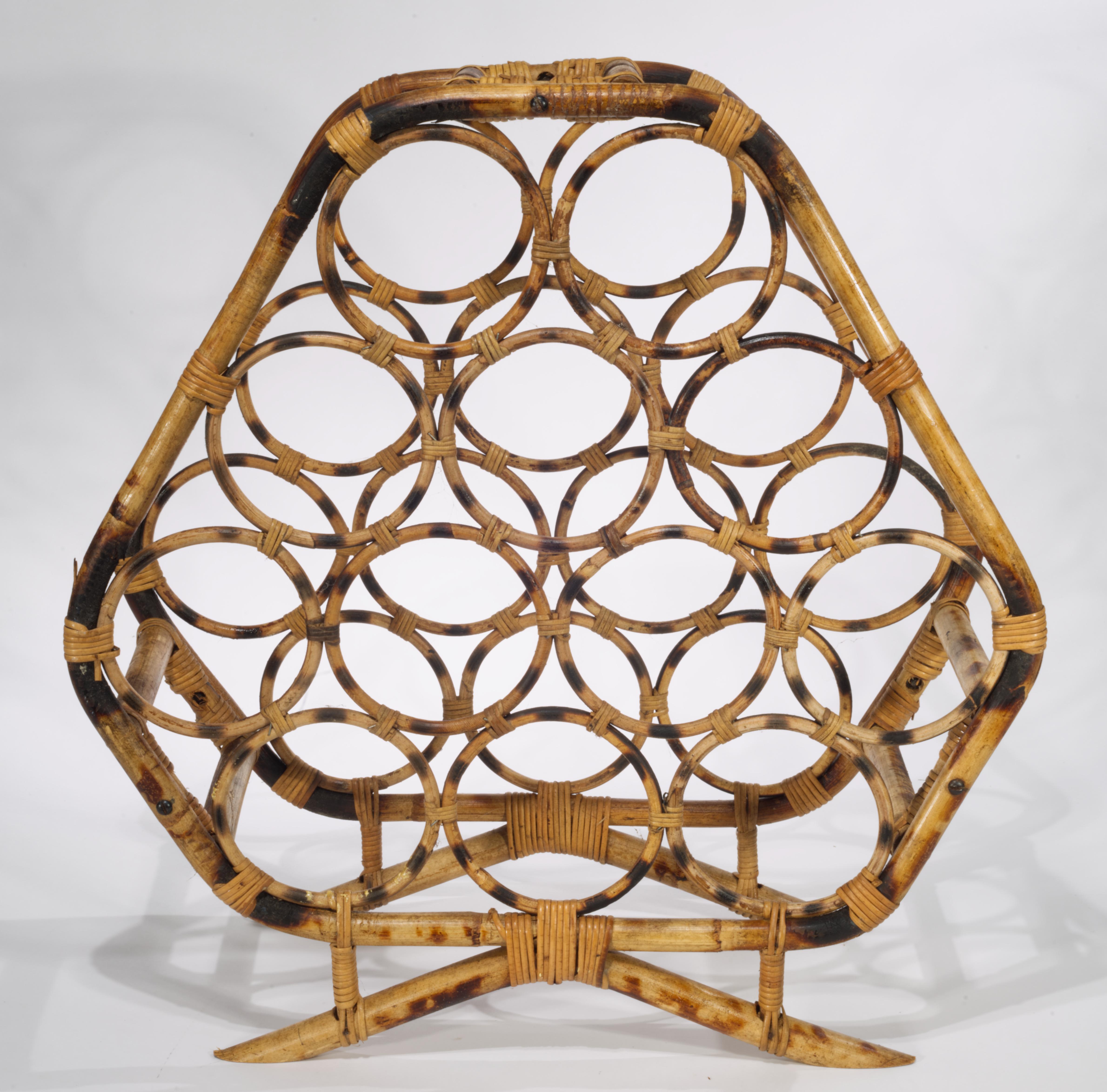  Il portabottiglie in bambù e rattan d'epoca presenta una struttura a più livelli con spazio per 12 bottiglie, collegate da un ampio telaio esterno ottagonale con maniglia superiore rettangolare e montate su piedi leggermente curvi. Il grande