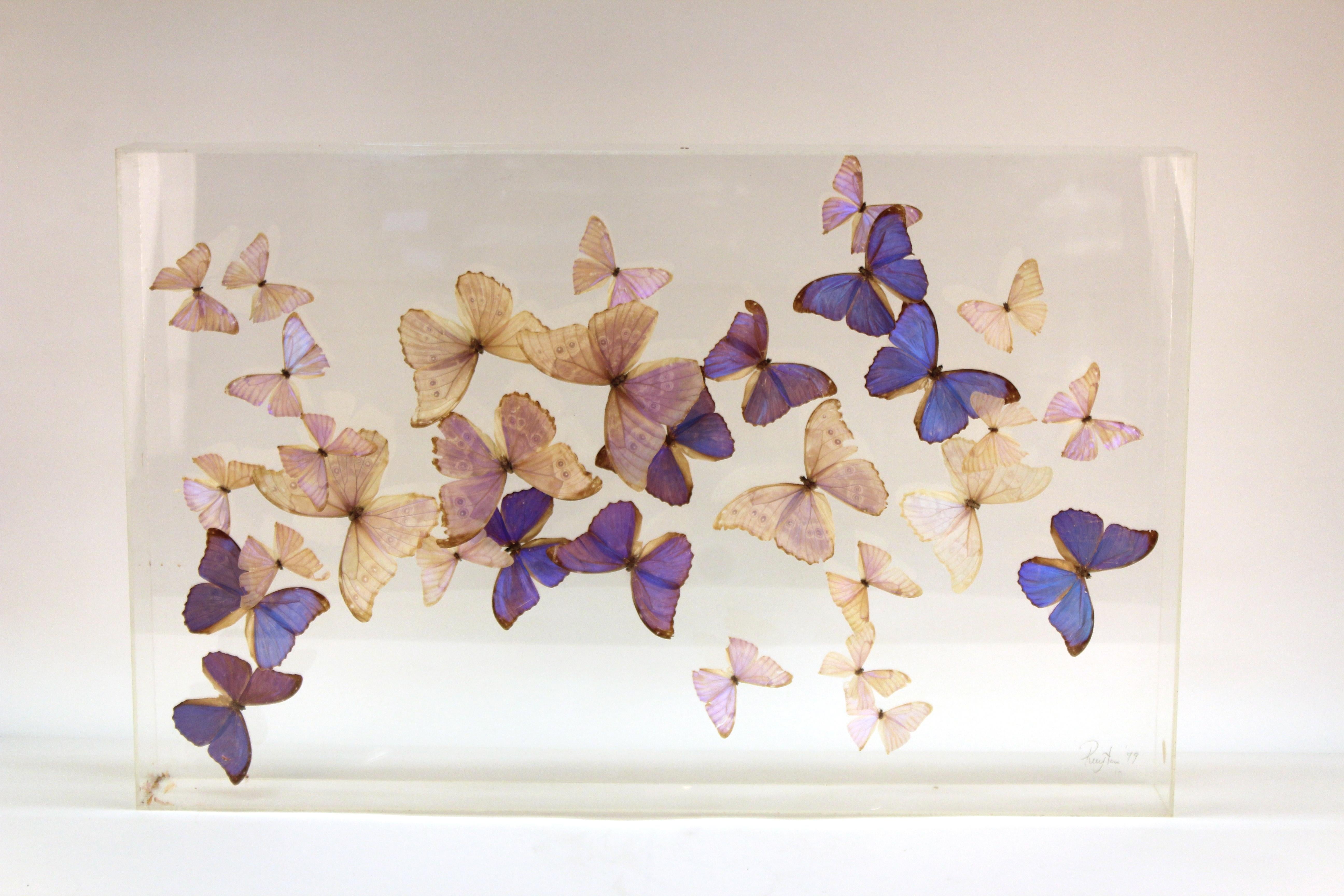 Mid-Century Modern wall art butterflies mounted inside a Lucite case. The piece has a signature and date in the lower right corner (Ruyten 1979) and has two Lucite hooks on the back for easy wall mounting. Likely made in the United States in 1979