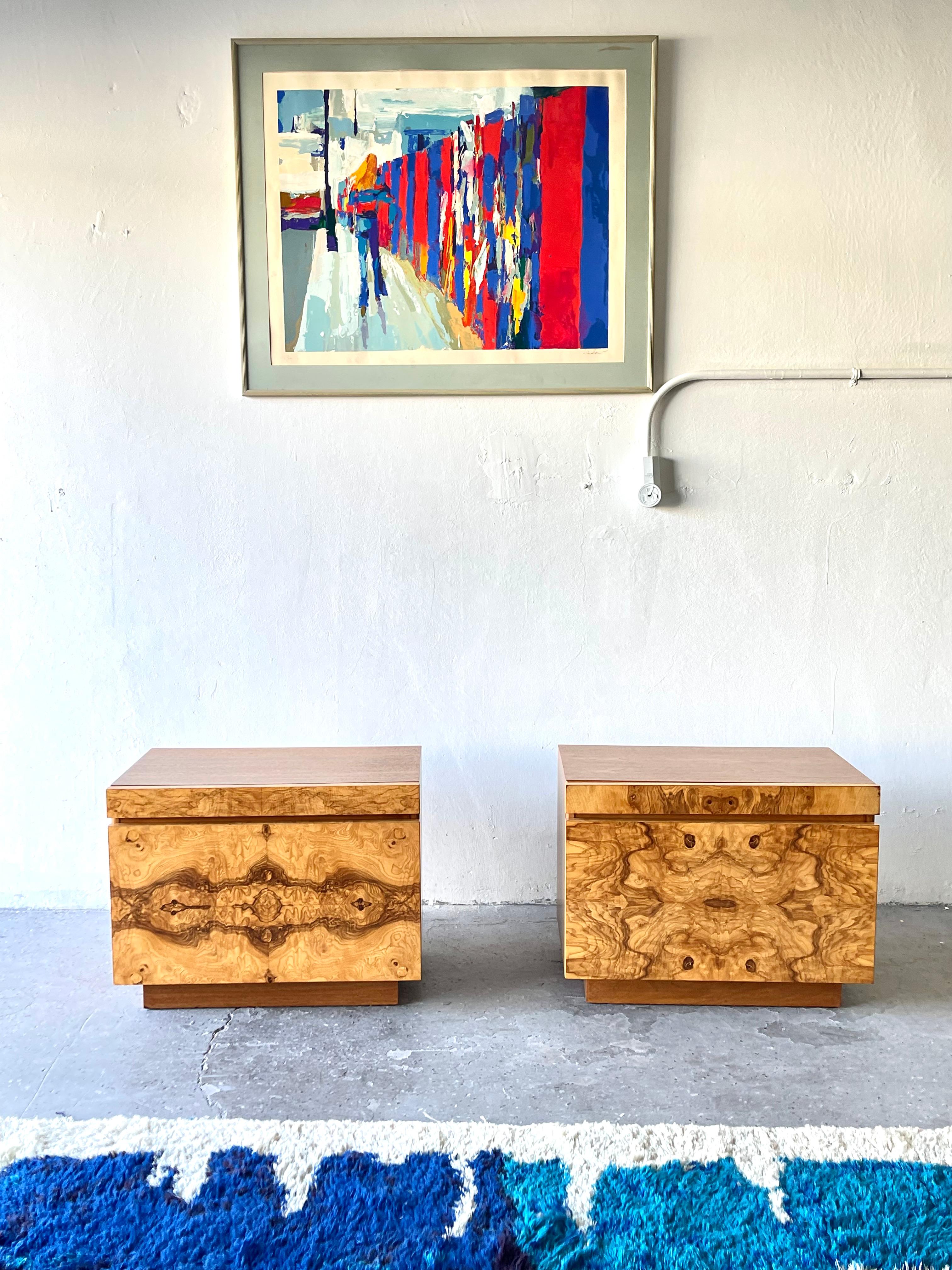 Super cool very high end pair of olive burl wood nightstands designed by Roland Carter for Lane Furniture Co. The cabinet fronts are covered in burl wood veneer with the tops and sides being solid wood. Each features a pull-out white laminate shelf