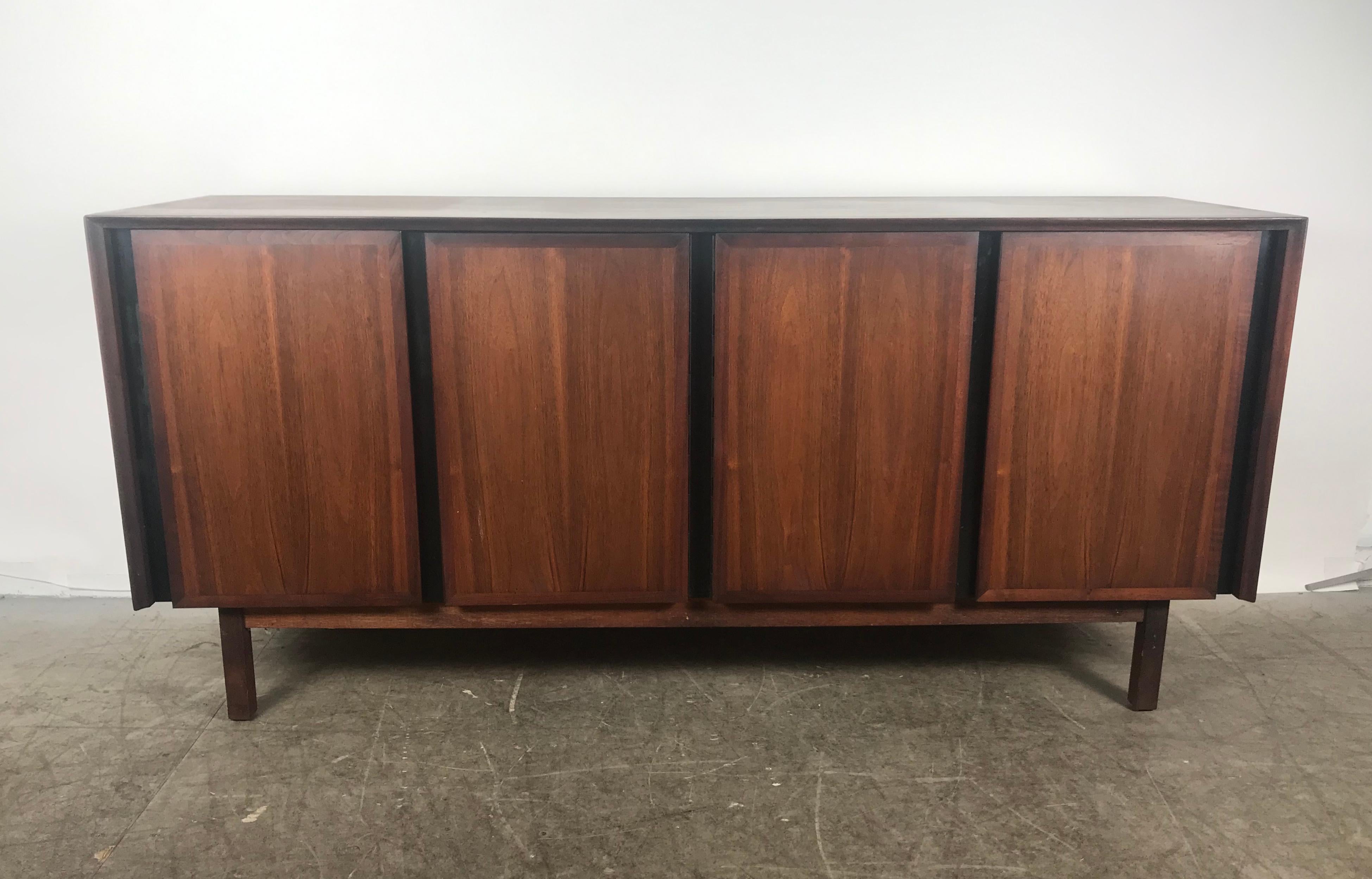 Stunning midcentury walnut credenza sideboard with top by Merton Gershun for Dillingham, circa 1970s.
Left doors open to three enclosed drawers. Right side doors reveal open shelves. Top features sliding glass doors, left cabinet with reversable