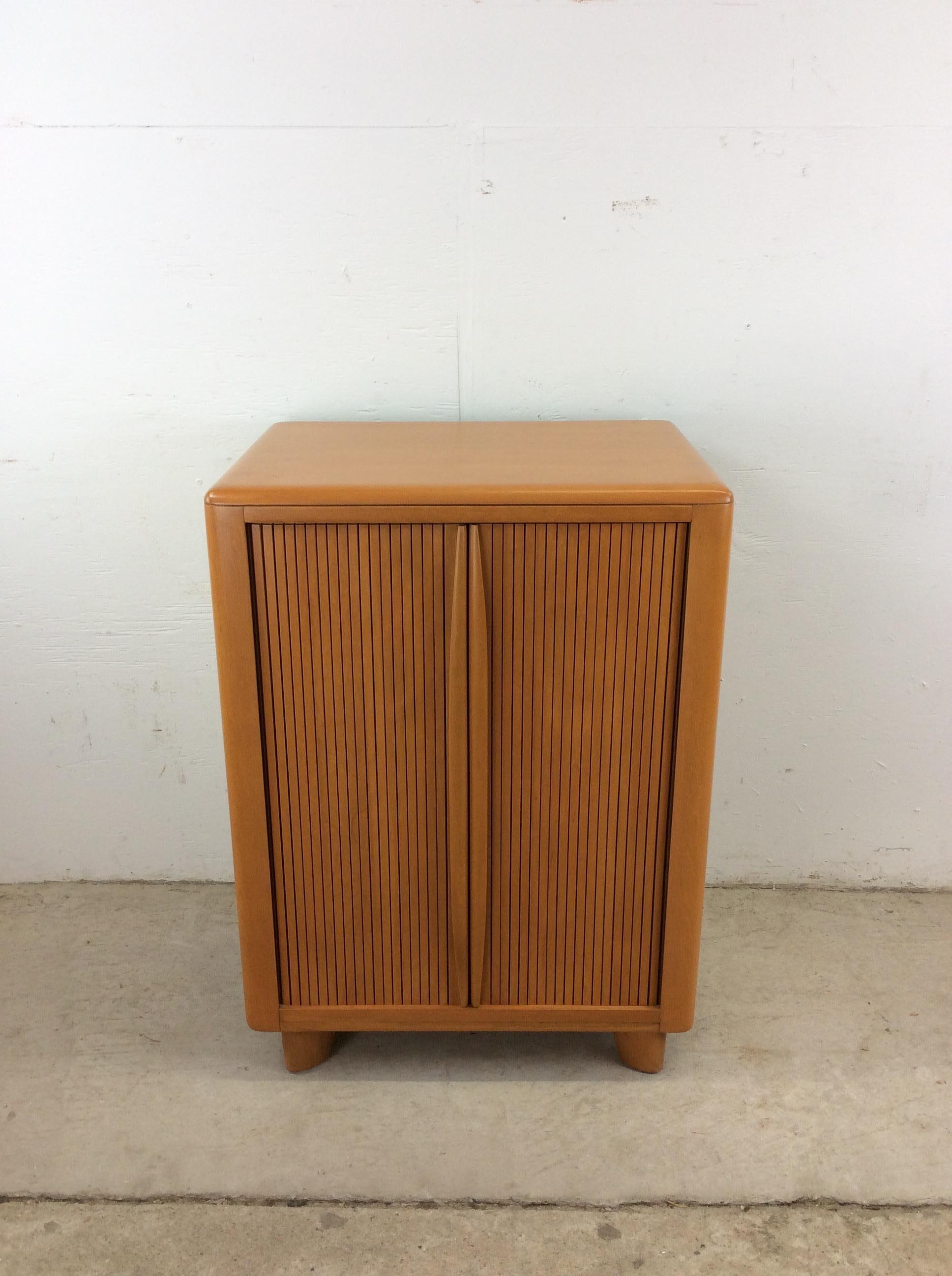 This mid century modern cabinet by Heywood Wakefield features hardwood construction, original champagne finish, tambour door with sculpted wood pulls, adjustable interior shelf, and small tapered legs.
Dimensions: 24w 17.25d 32.5h

Condition notes: