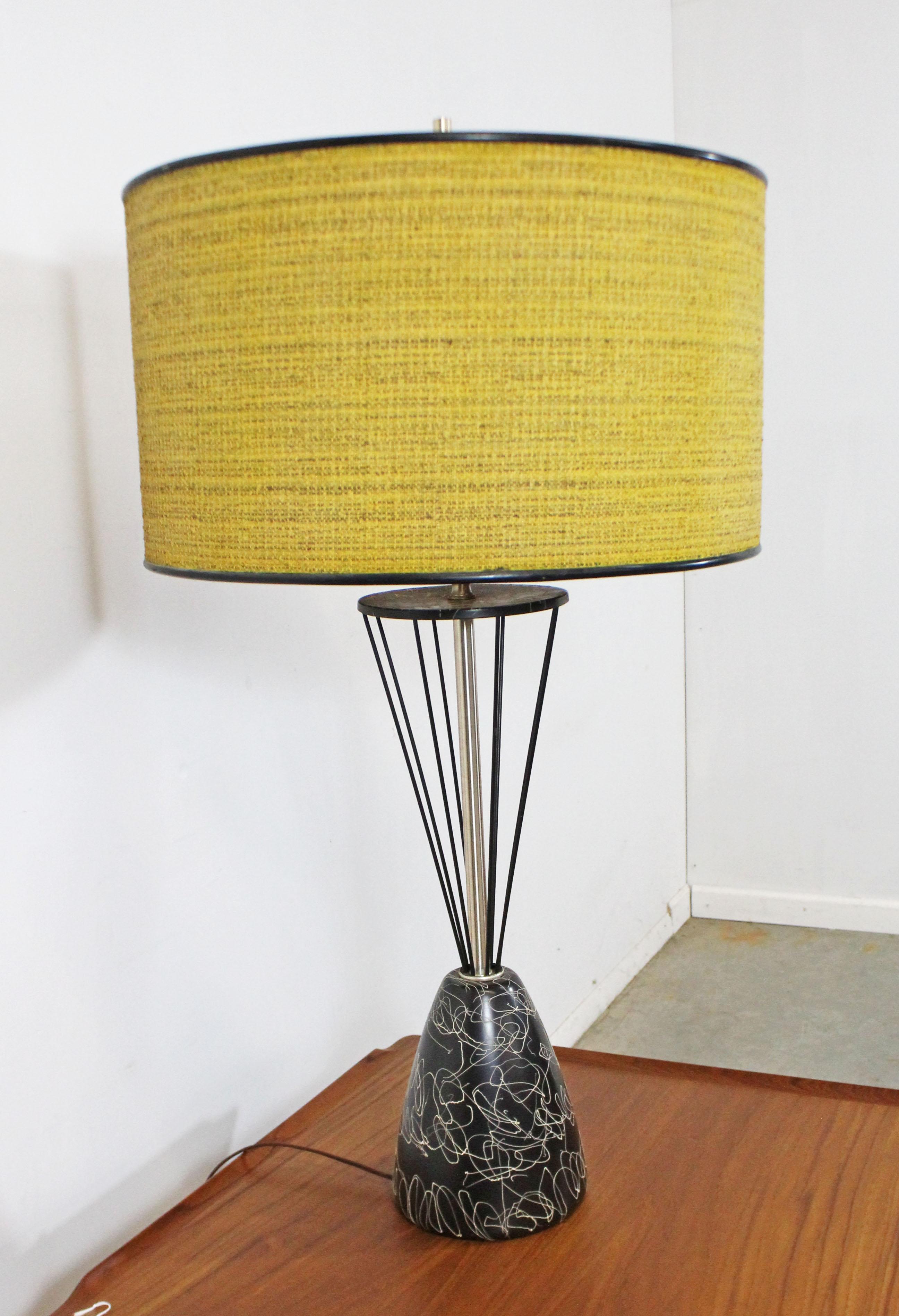Offered is a one of a kind custom made Mid-Century Modern table lamp with a caged wire-base and drum shade. This lamp has a painted metal and wire base. The drum shade sits on a glass shade (see photos). In good, working condition, but can stand to
