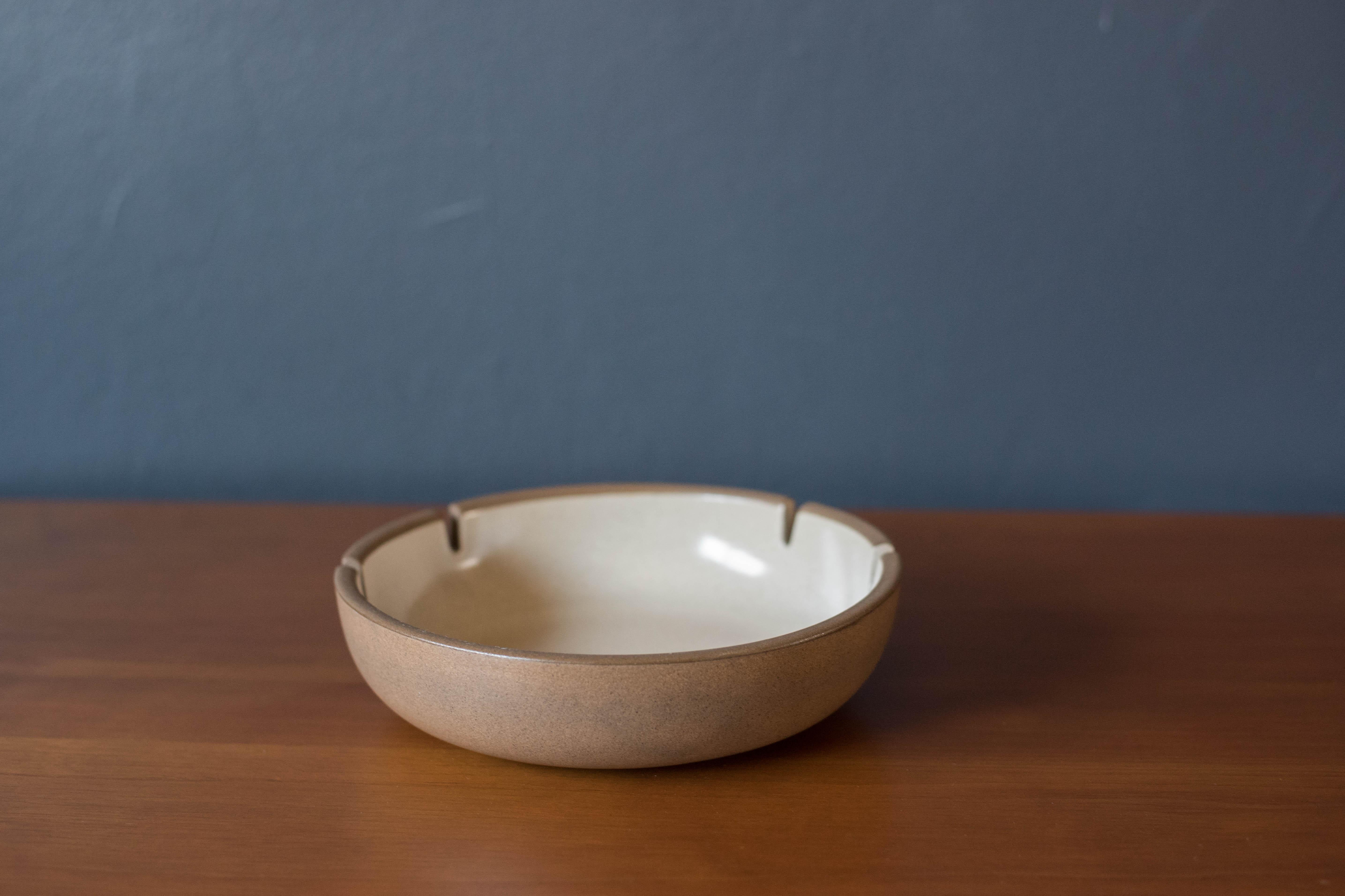 Vintage stoneware studio pottery ashtray designed by Edith and Brian Heath for Heath Ceramics of Sausalito, California. Features a two-tone contrasting 'sandalwood' glaze that displays a natural matte taupe and ivory speckled gloss finish. 