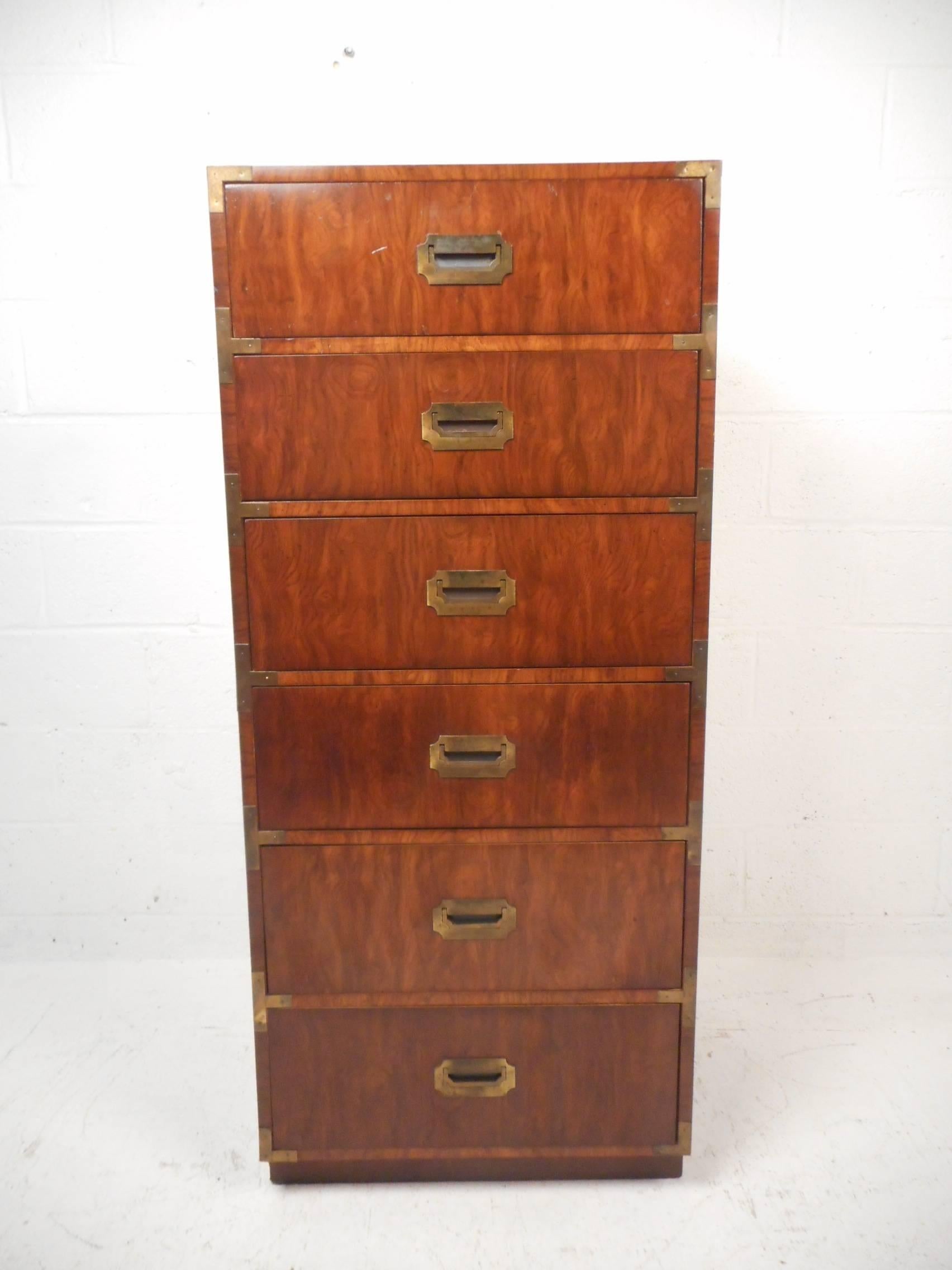 A gorgeous vintage modern Campaign chest of drawers by Dixie from the 1960s. This stylish tall dresser features six hefty drawers with unique brass pulls on the centre of each. The unique design offers plenty of room for storage without taking up